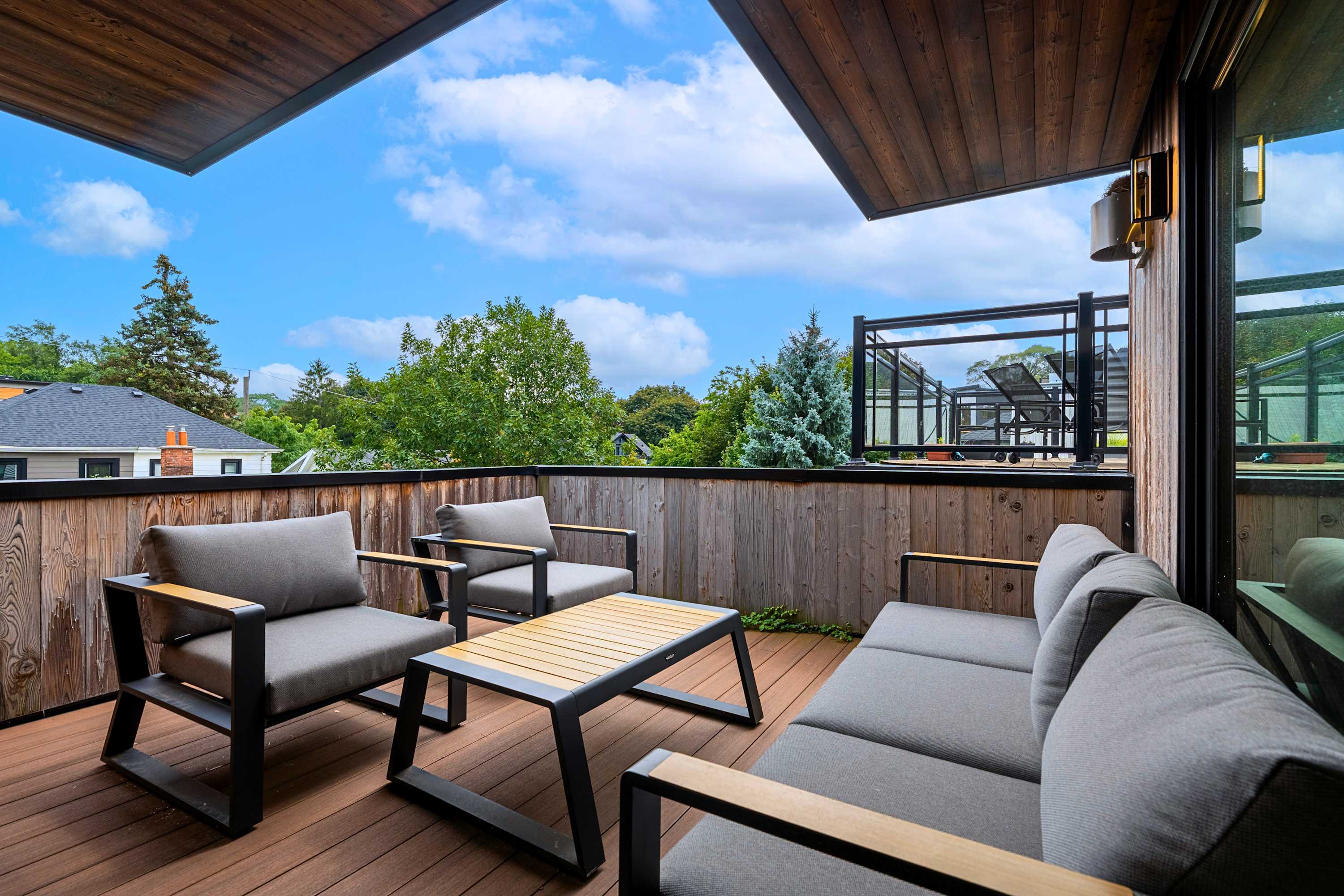 Private upper terrace with comfortable seating and glass sliding door access.