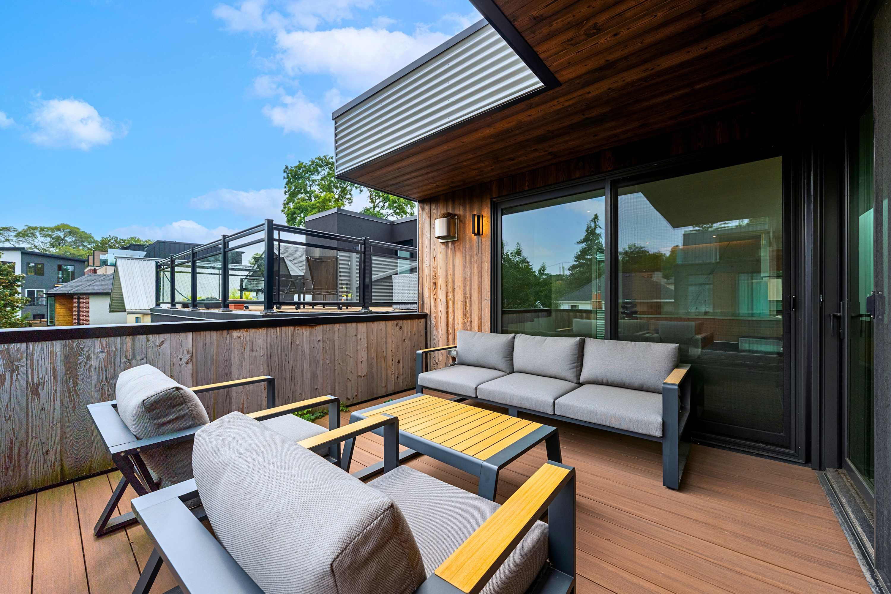 Secluded outdoor lounge balcony overlooking lush private neighborhood greenery.