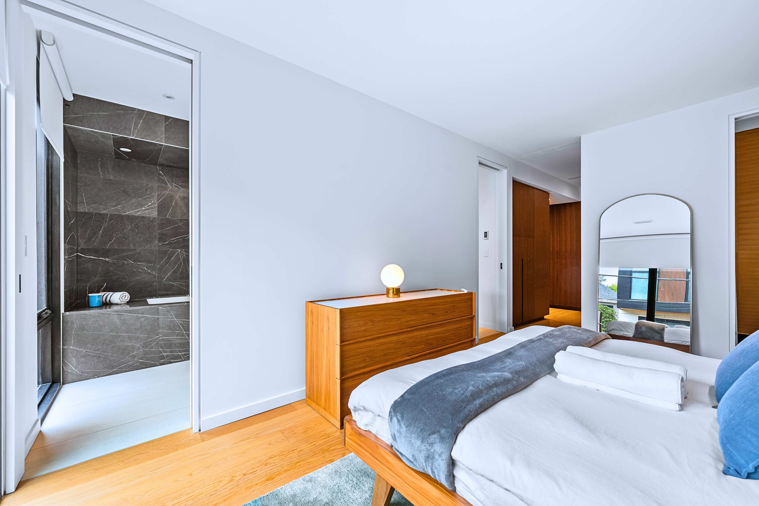Minimalist king bedroom with hardwood floors and generous wardrobe space.