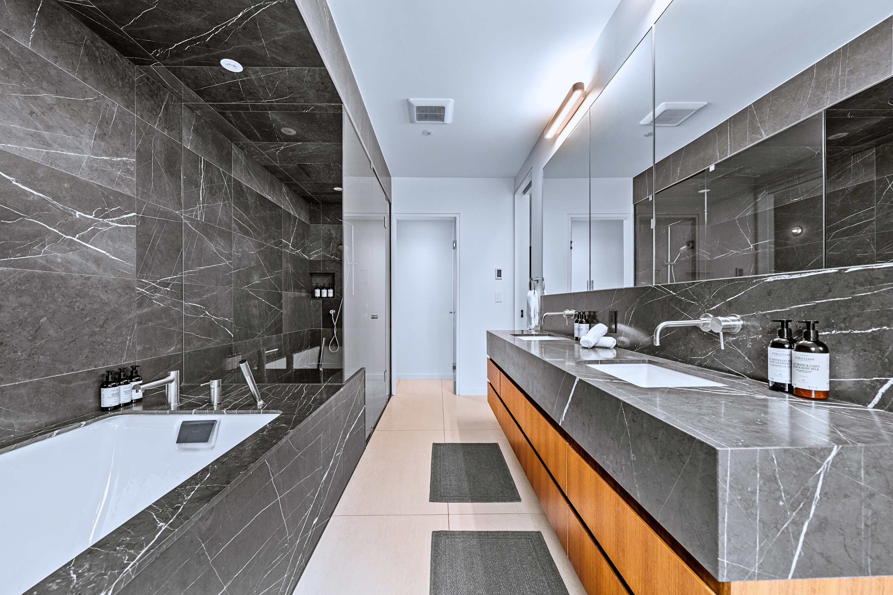 Primary bath suite with deep tub, double vanity, and frameless glass shower.