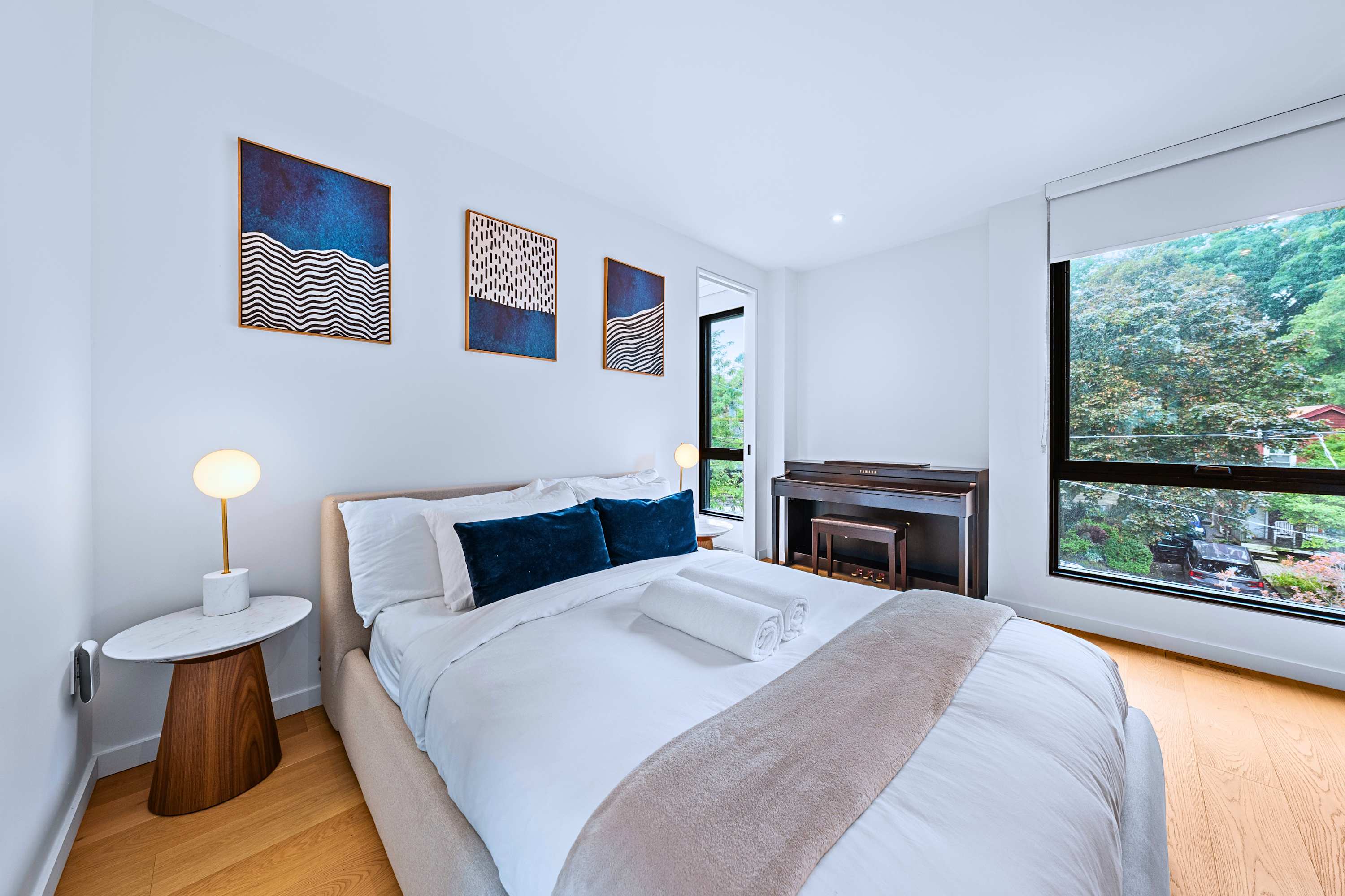 Tranquil queen suite with plush bedding and large corner windows.