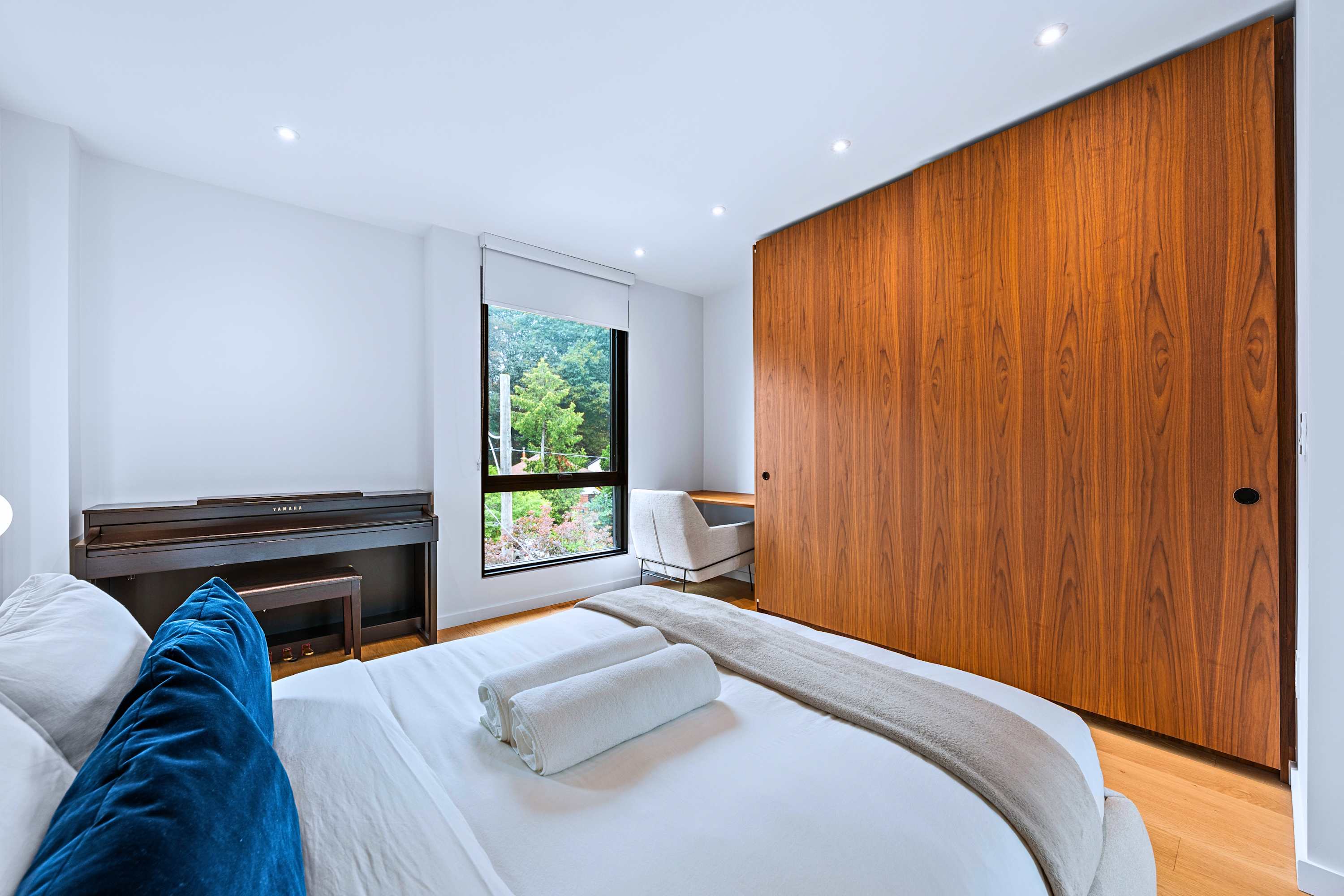 Secondary bedroom featuring floor-to-ceiling timber wardrobe and desk area.