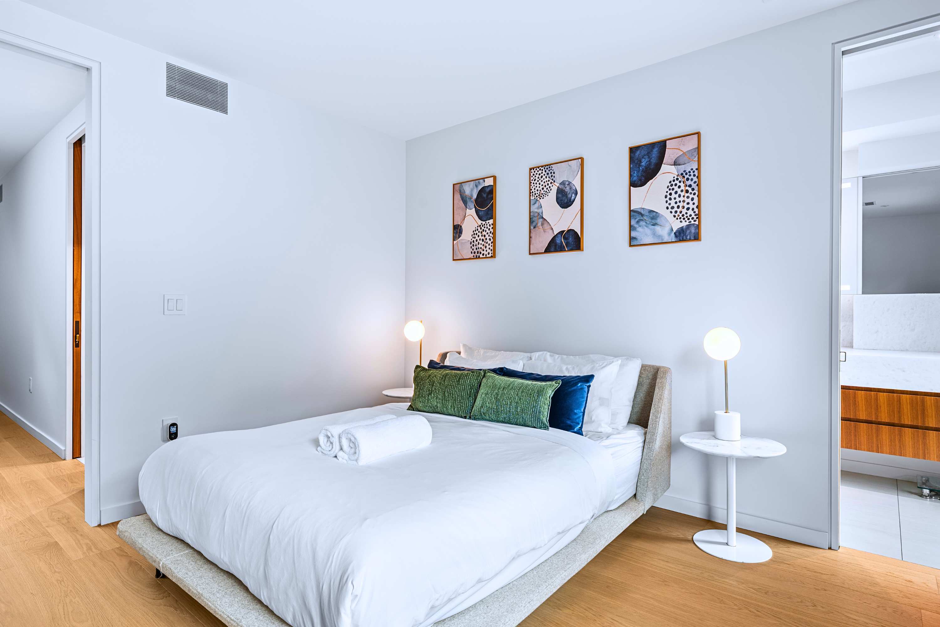 Cozy queen bedroom setup offering clean contemporary wall accents.