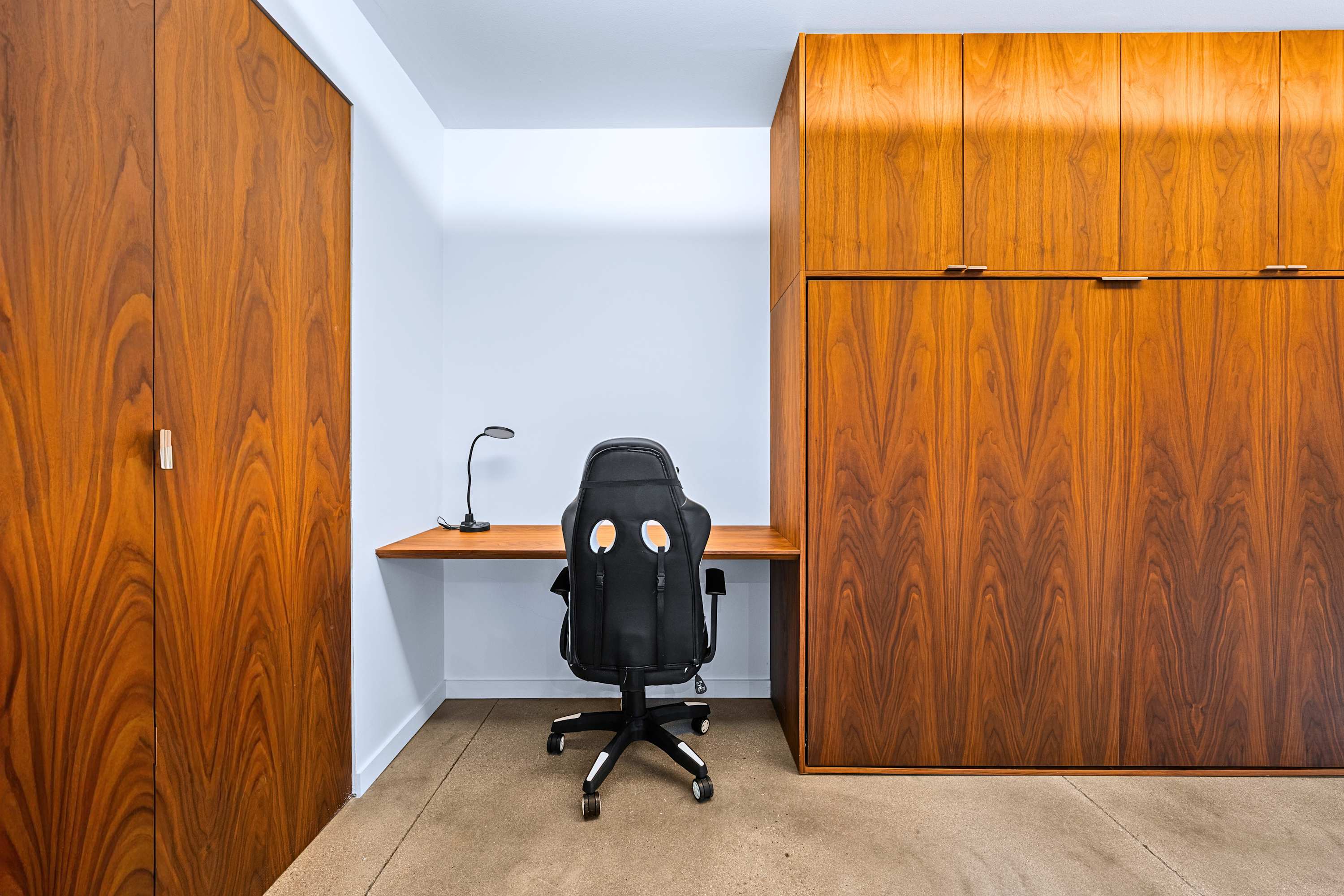 Dedicated workstation nook with ergonomic seating and warm wood paneling.