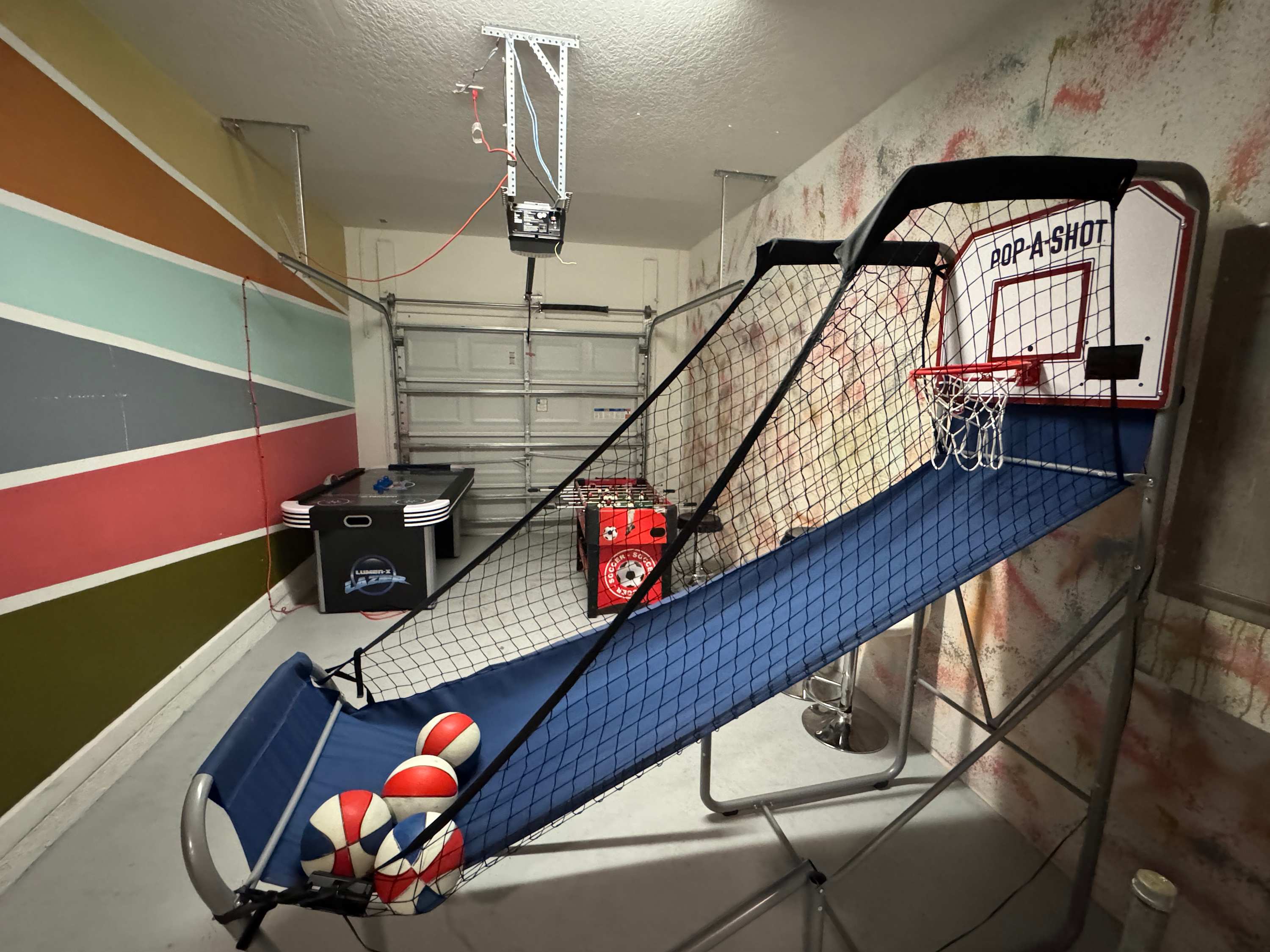 Private game room with basketball arcade play, a foosball table, air hockey, and a dedicated shooting area for family-friendly competition.