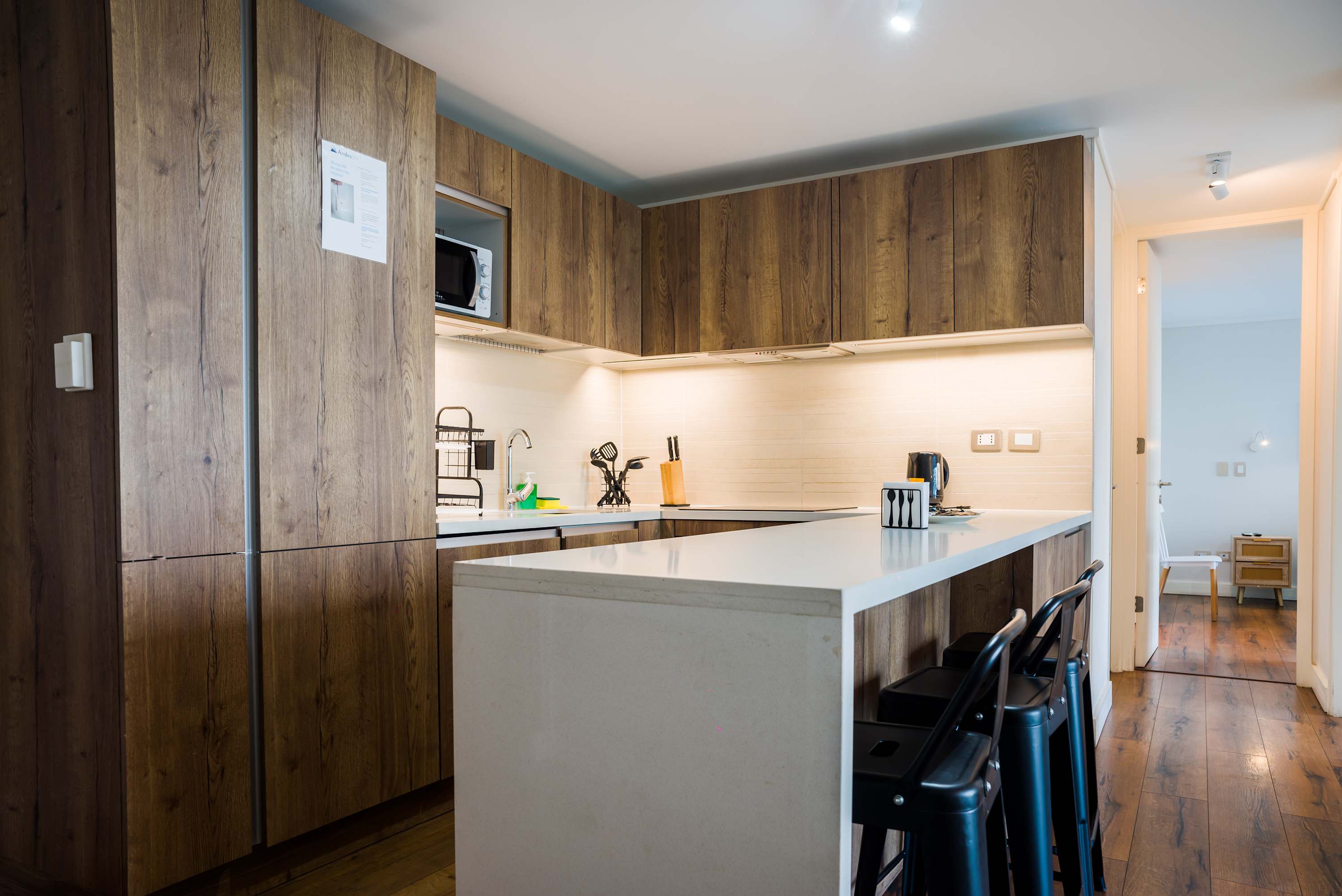 Modern wood-accented kitchen with a generous white island, induction cooktop, and bar seating for relaxed meals and conversation.
