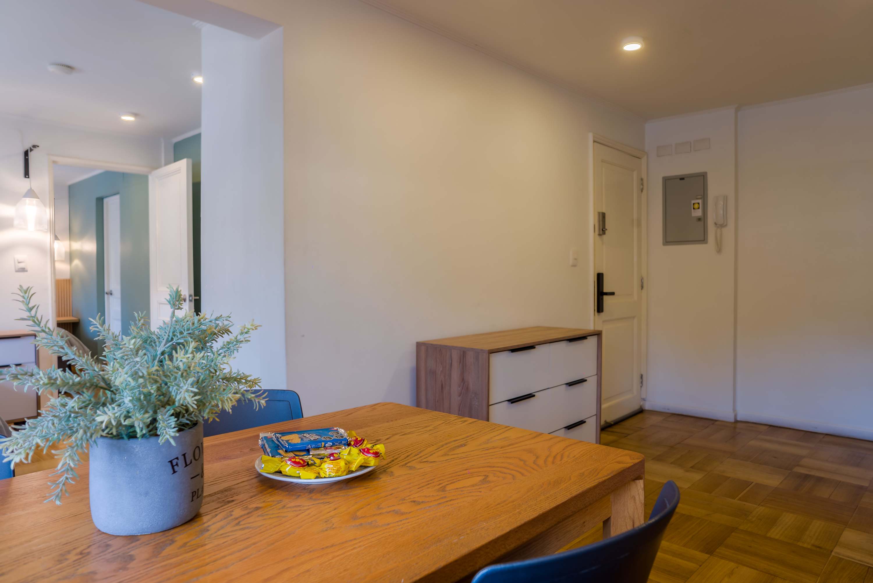 Private dining area with a spacious wood table, blue chairs, and a welcoming snack setup for shared meals.