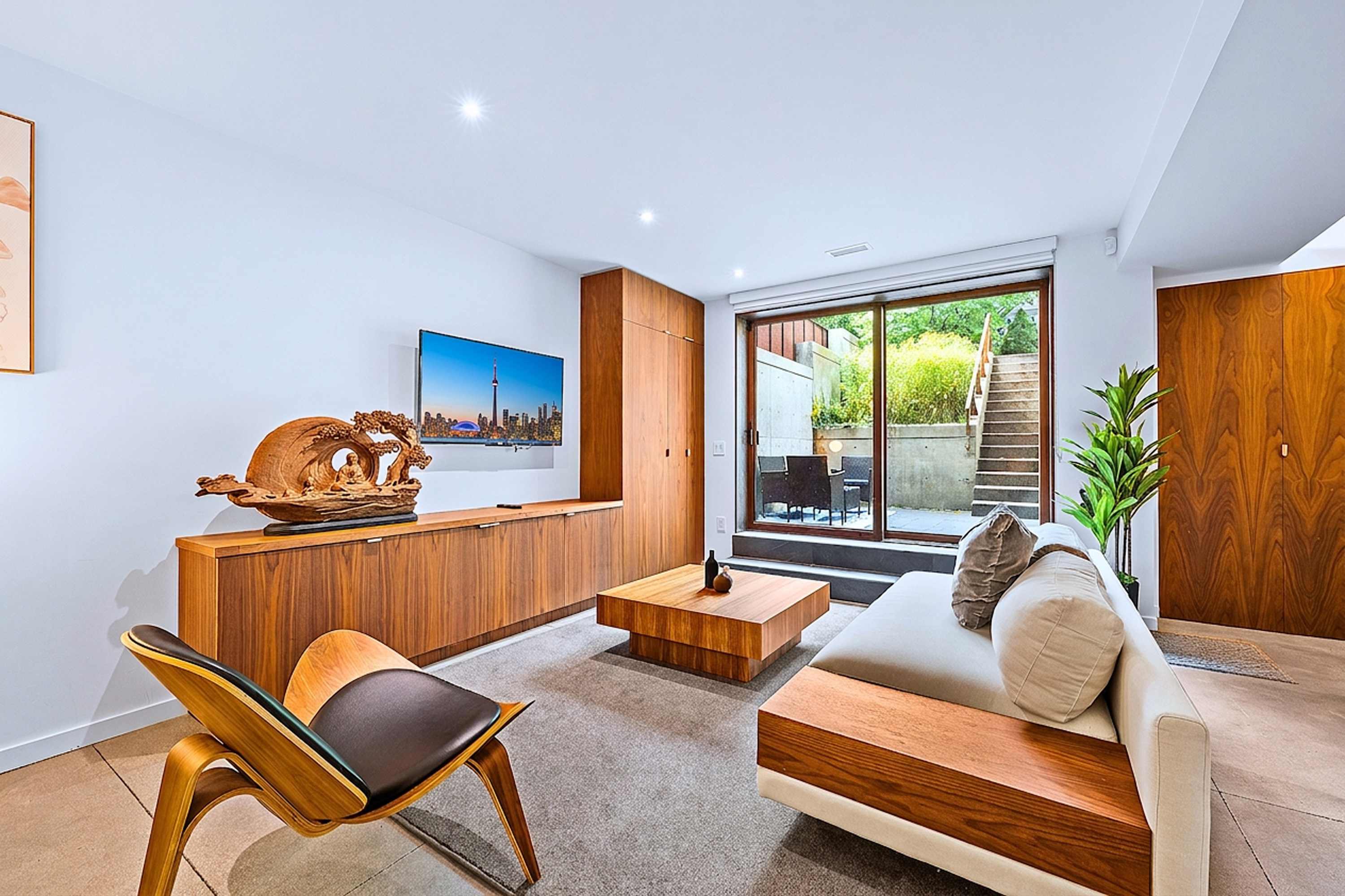Premium designed living room with a designer couch, accent chair, and access to a private patio.