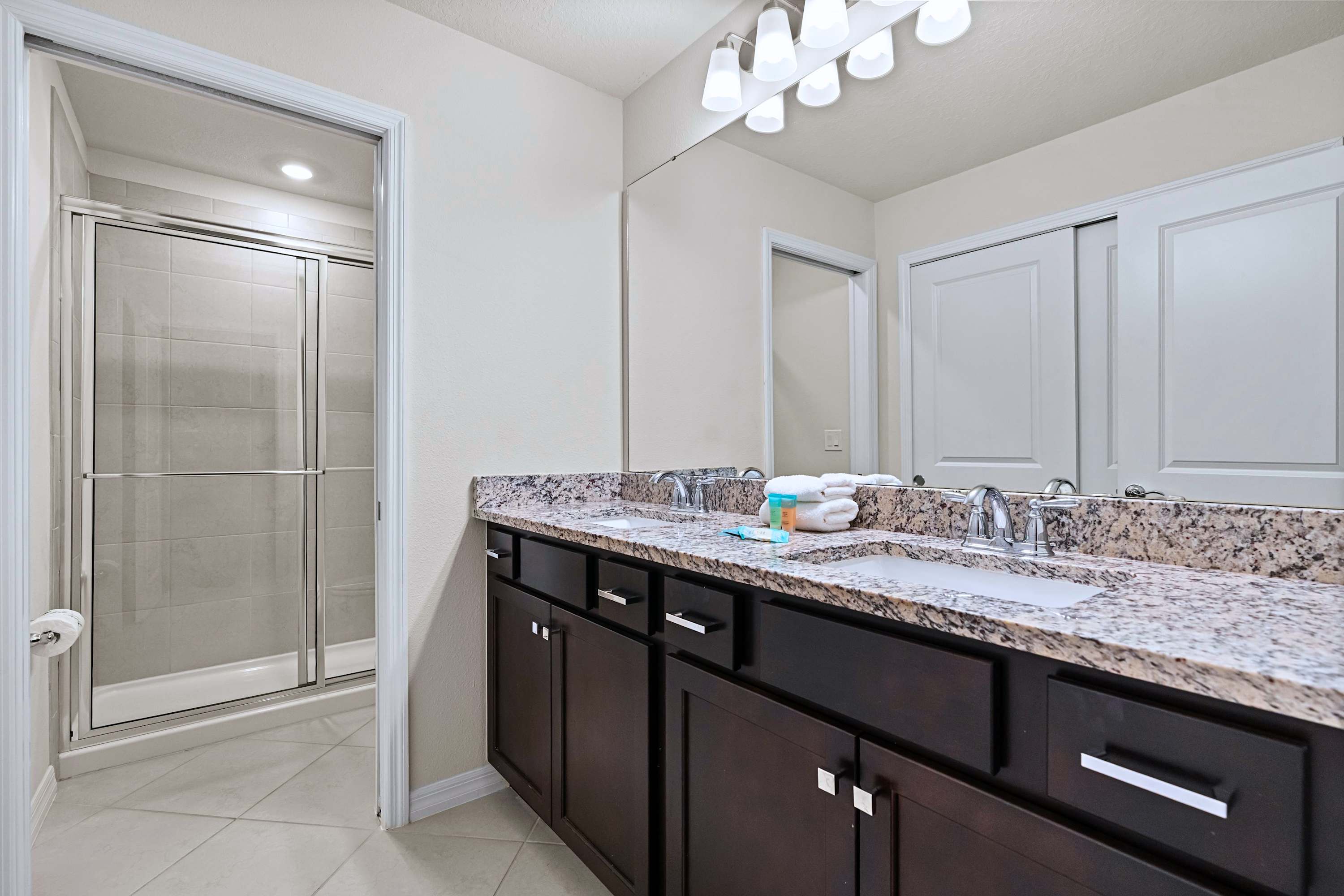 Refresh with room to spare—featuring a double vanity, oversized mirror, and walk-in shower.