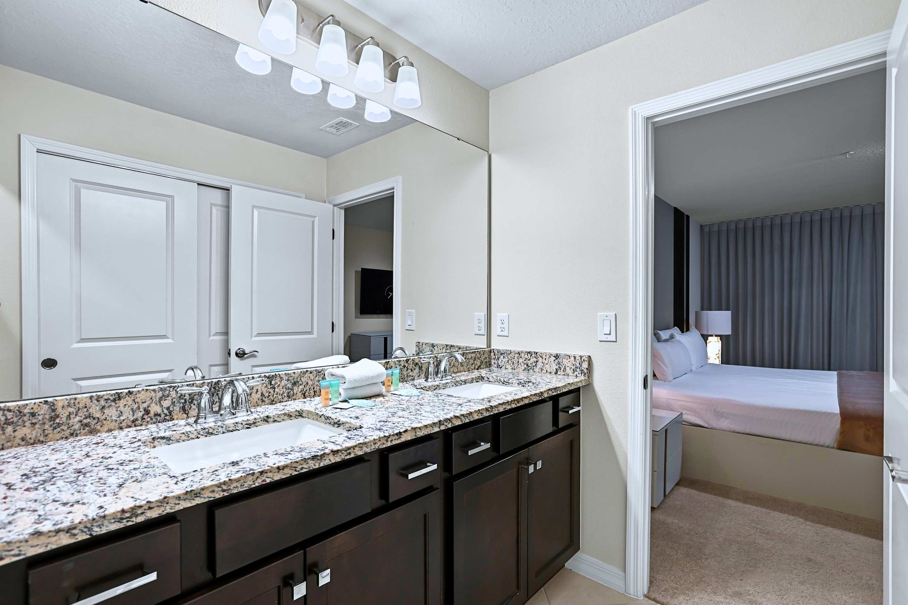 Designed for sharing: twin vanity sinks framed by a large illuminated mirror for easy mornings.