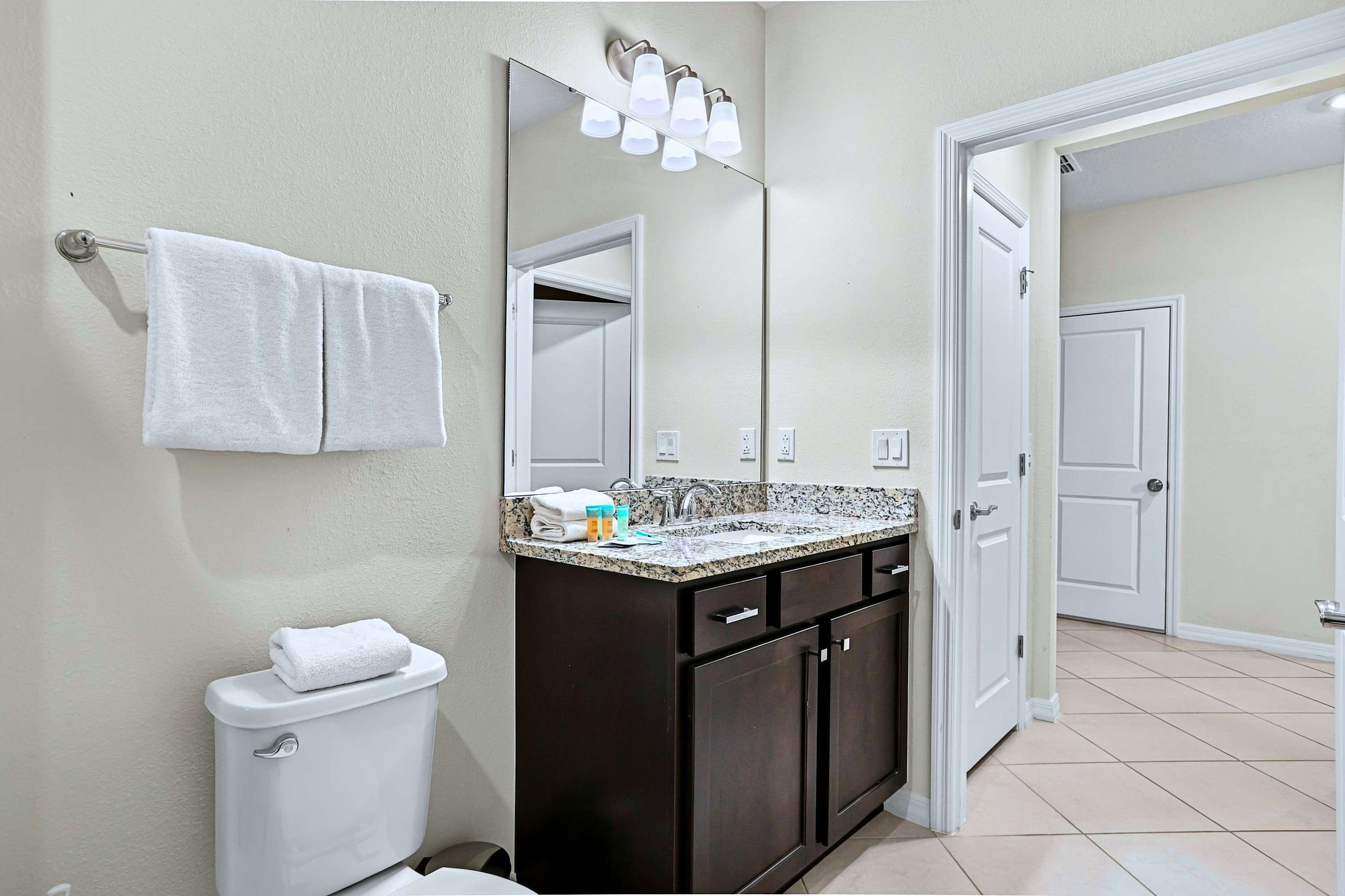 Clean, minimalist setup featuring flattering lights, a polished mirror, and modern fixtures. 