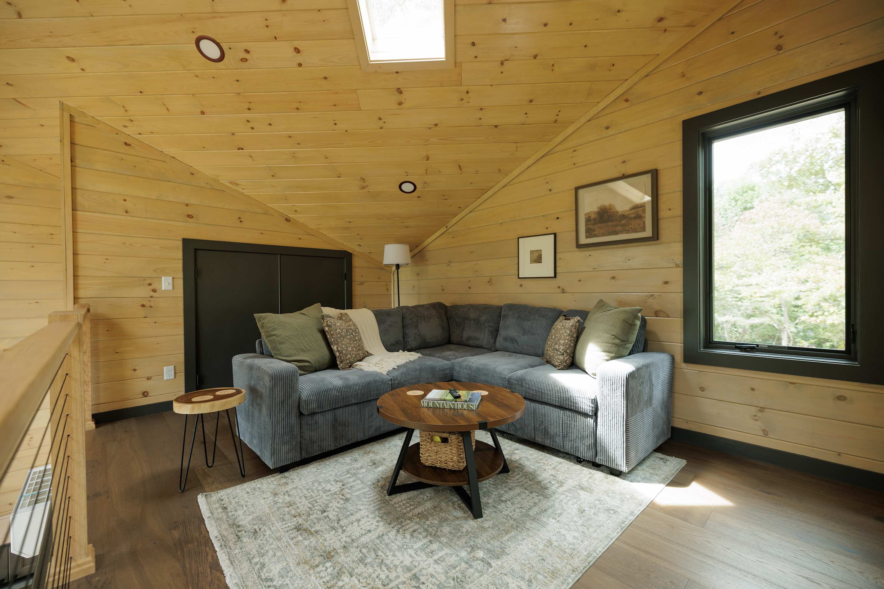A different angle showcasing the living room and loft above. The sleeper sofa is the perfect space to enjoy your favorite shows and movies! 