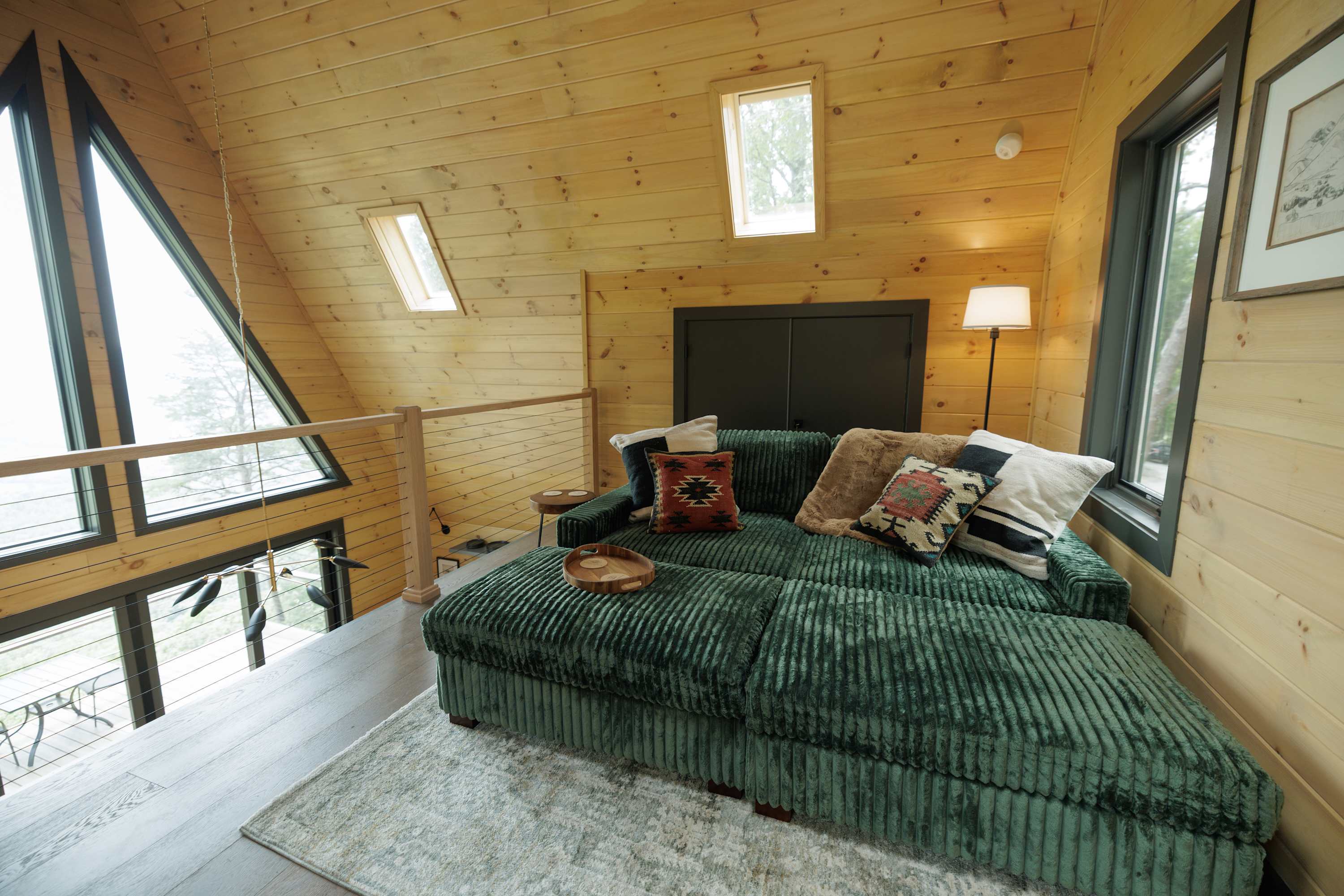 The loft with Skylight & Angled A-Frame Ceilings. You can turn the upstairs couch into a bed by pushing the ottomans together with the couch. 
