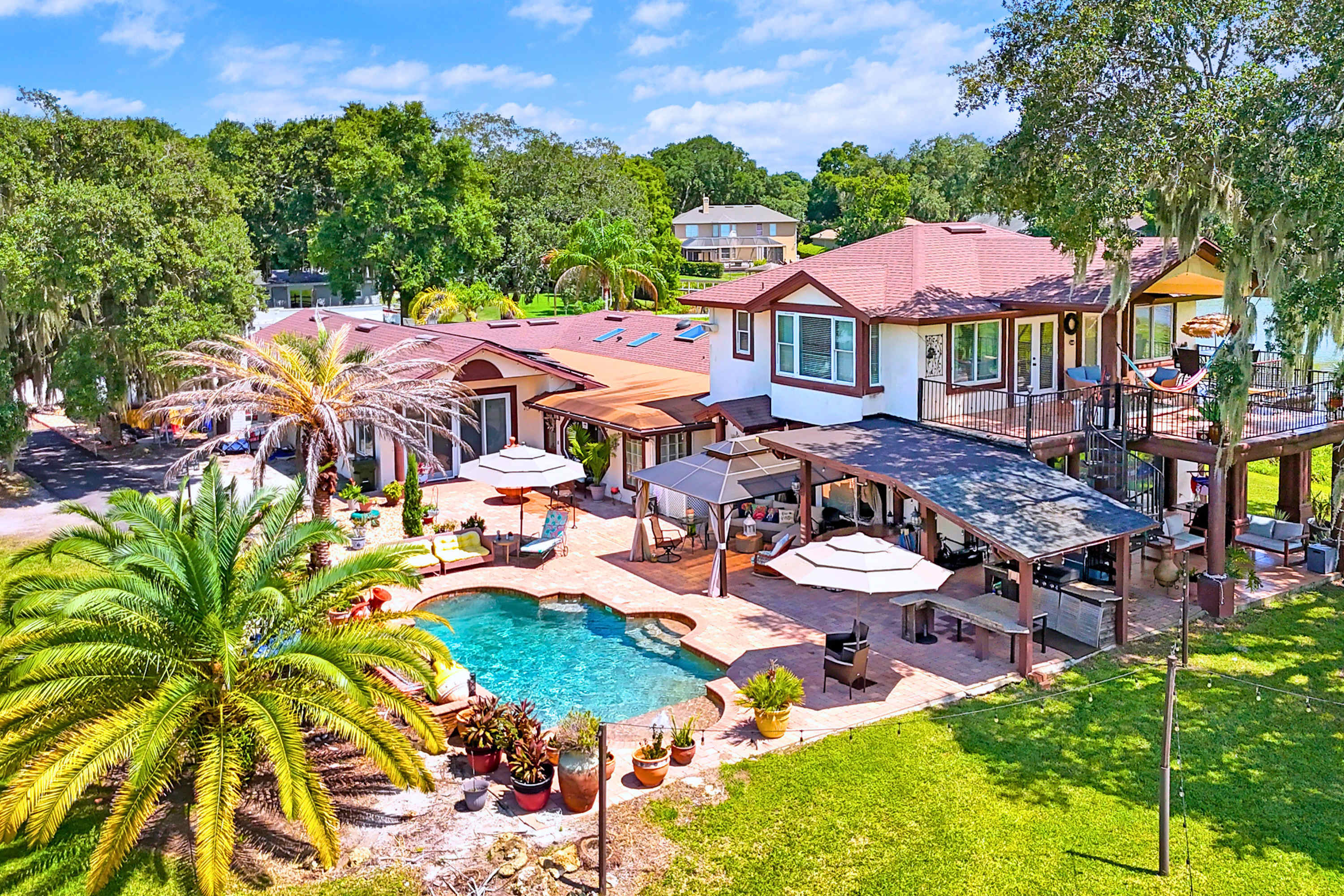 Panoramic view of the pool, outdoor lounge, and scenic second floor guest retreat