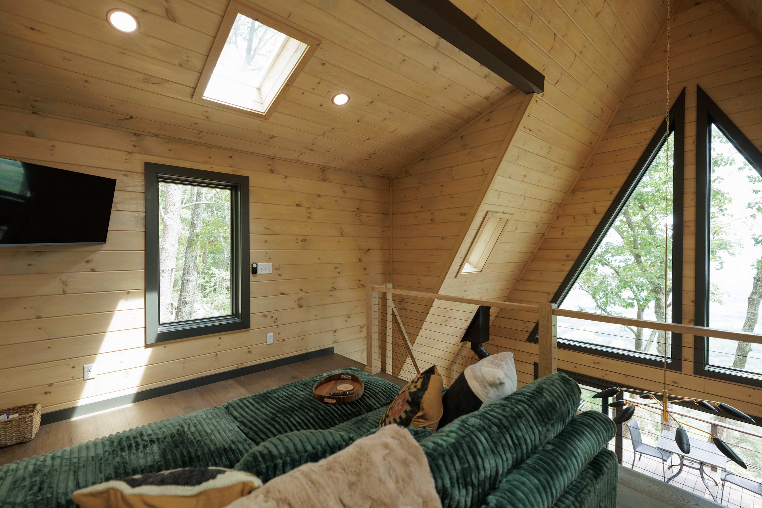 The loft with Skylight & Angled A-Frame Ceilings. You can turn the upstairs couch into a bed by pushing the ottomans together with the couch. 