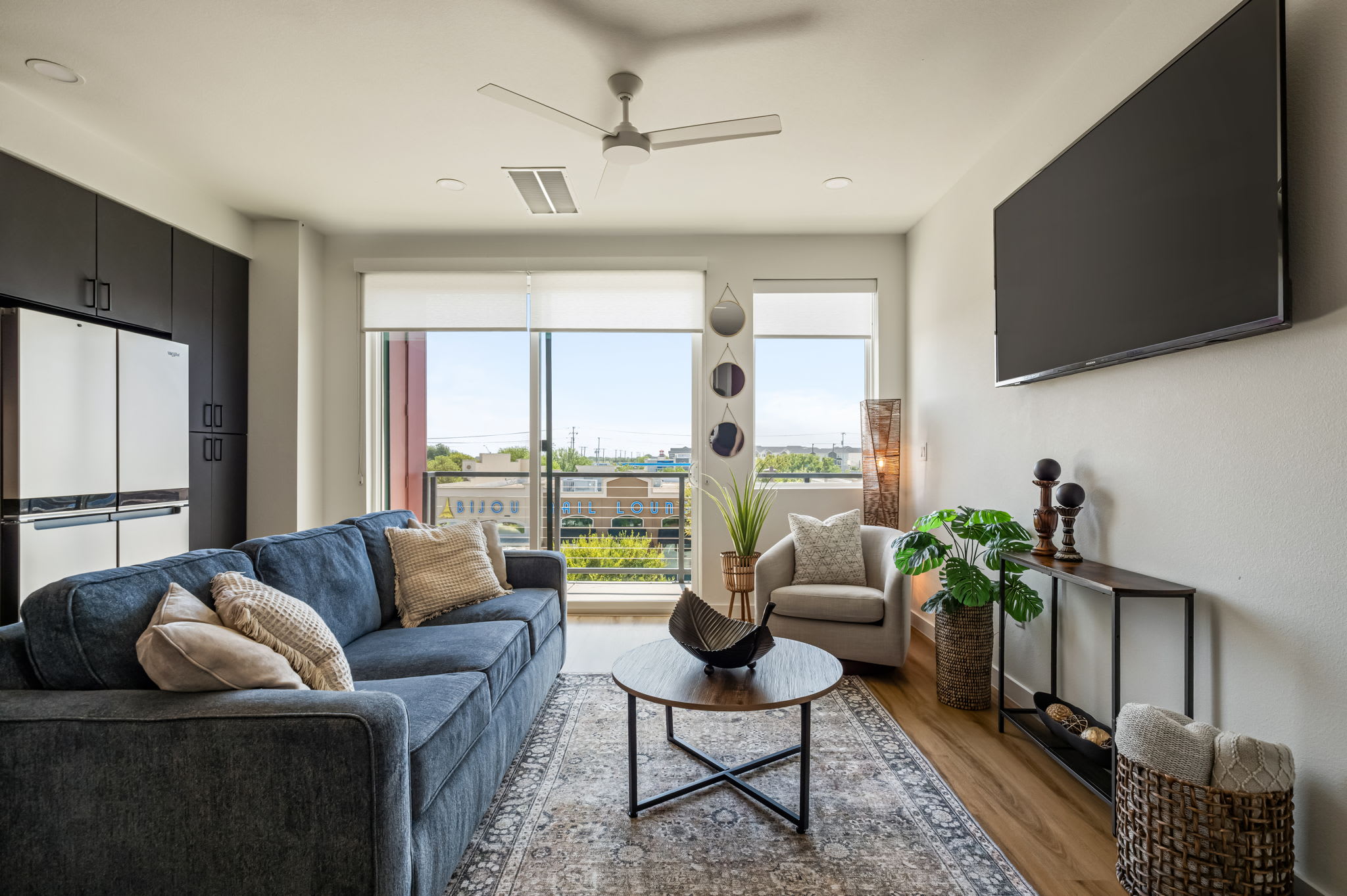 Living room with blue sectional and balcony doors