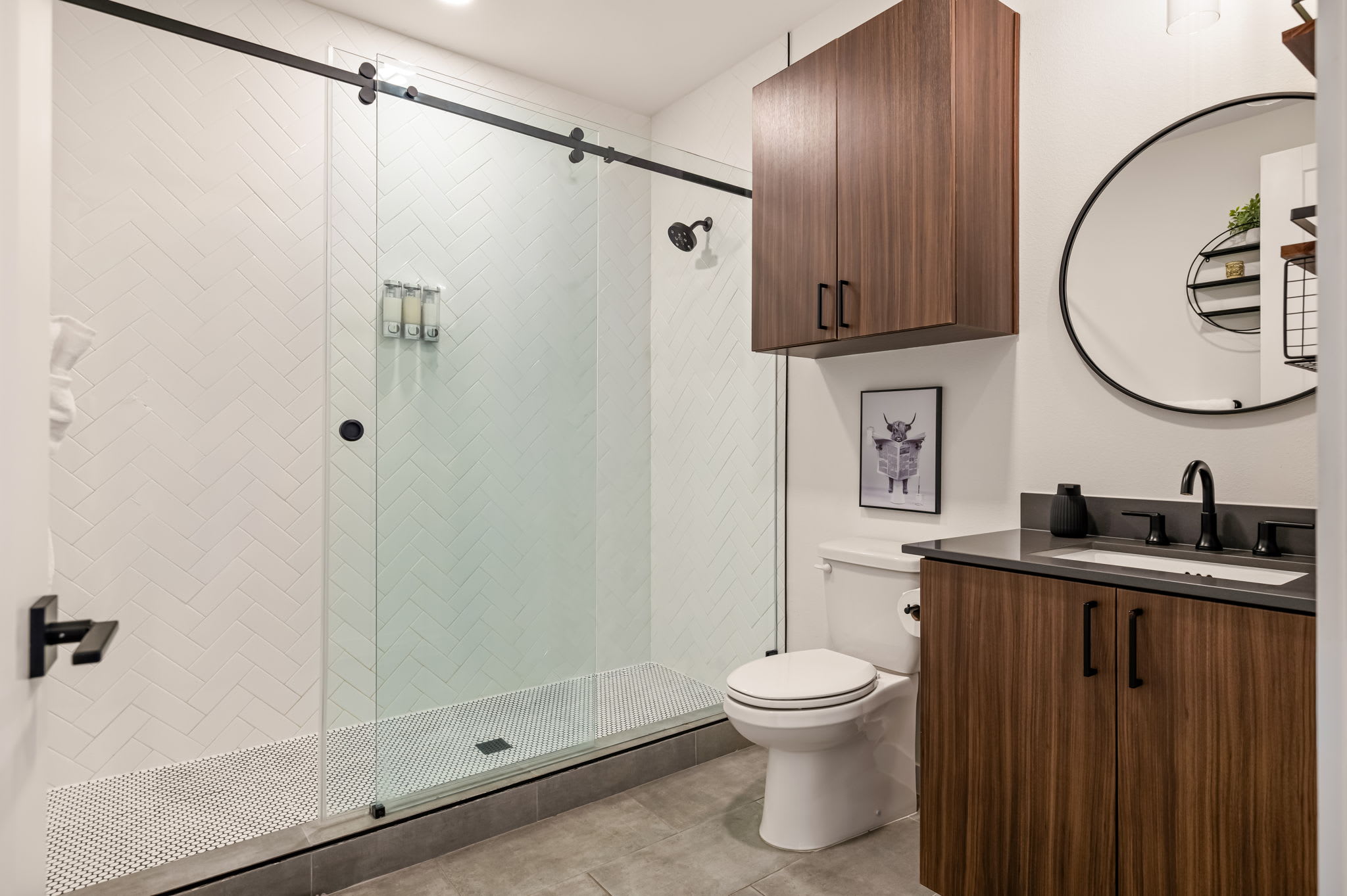 Bathroom with glass walk-in shower and round mirror
