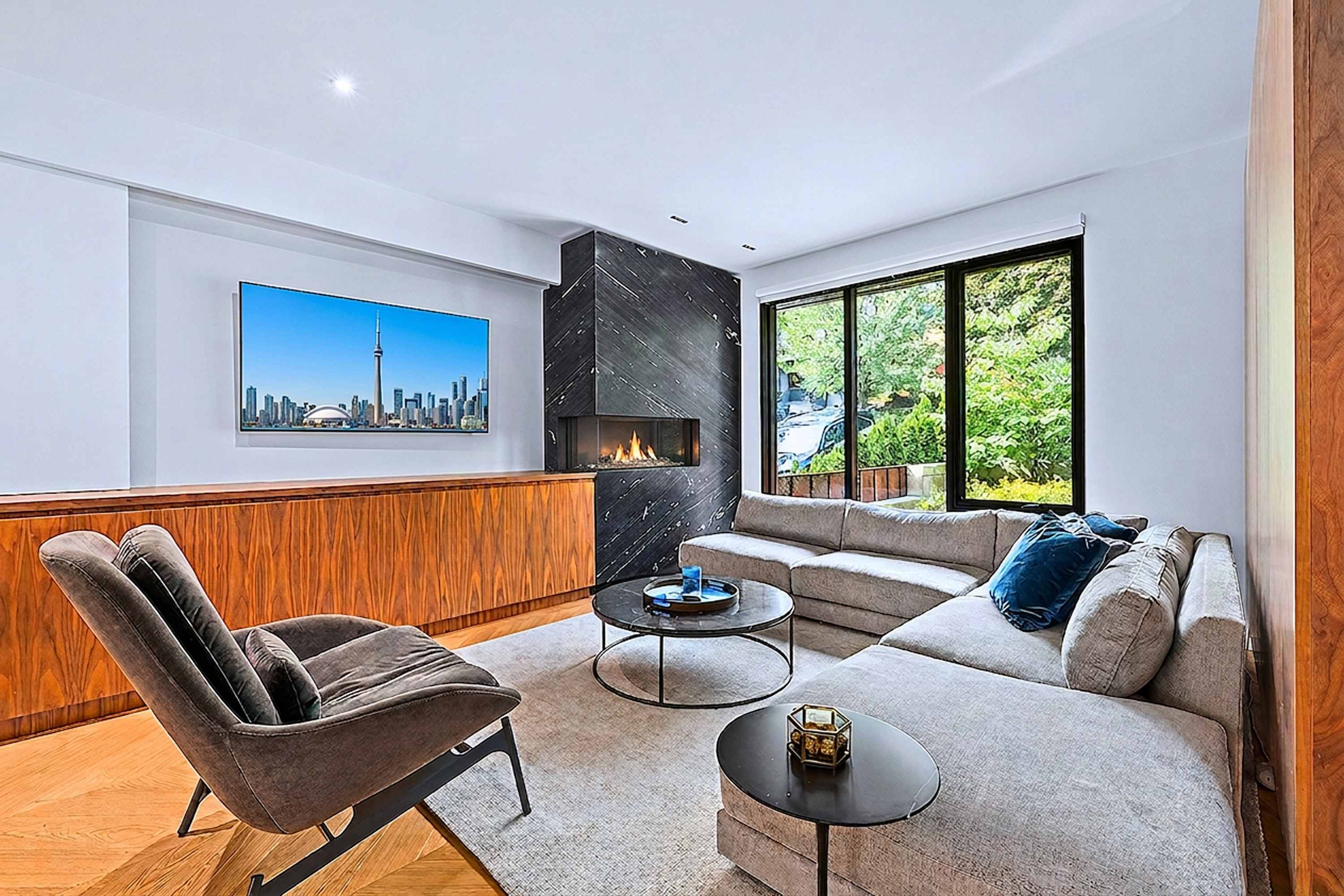 Secondary lounge with fireplace, large windows, and custom built-in storage.