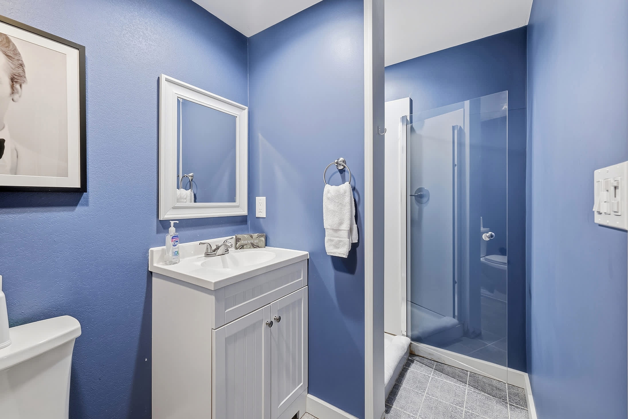 Basement bathroom with glass walk in shower and compact vanity setup.