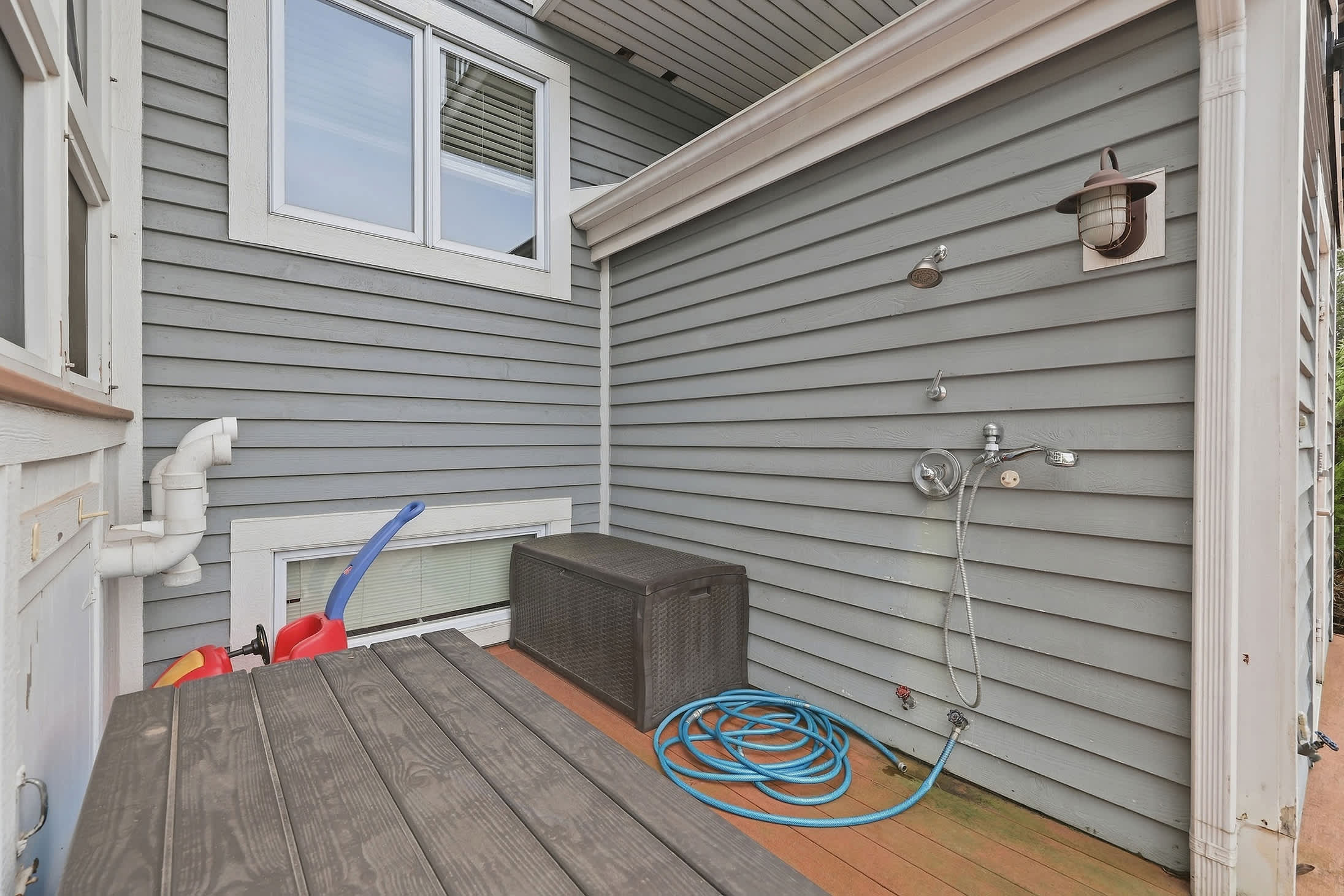 Outdoor shower area with hose for quick cleanup after pool time.