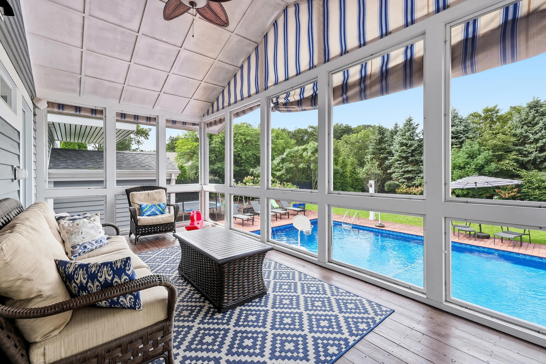 Screened porch with seating and direct views of the pool.