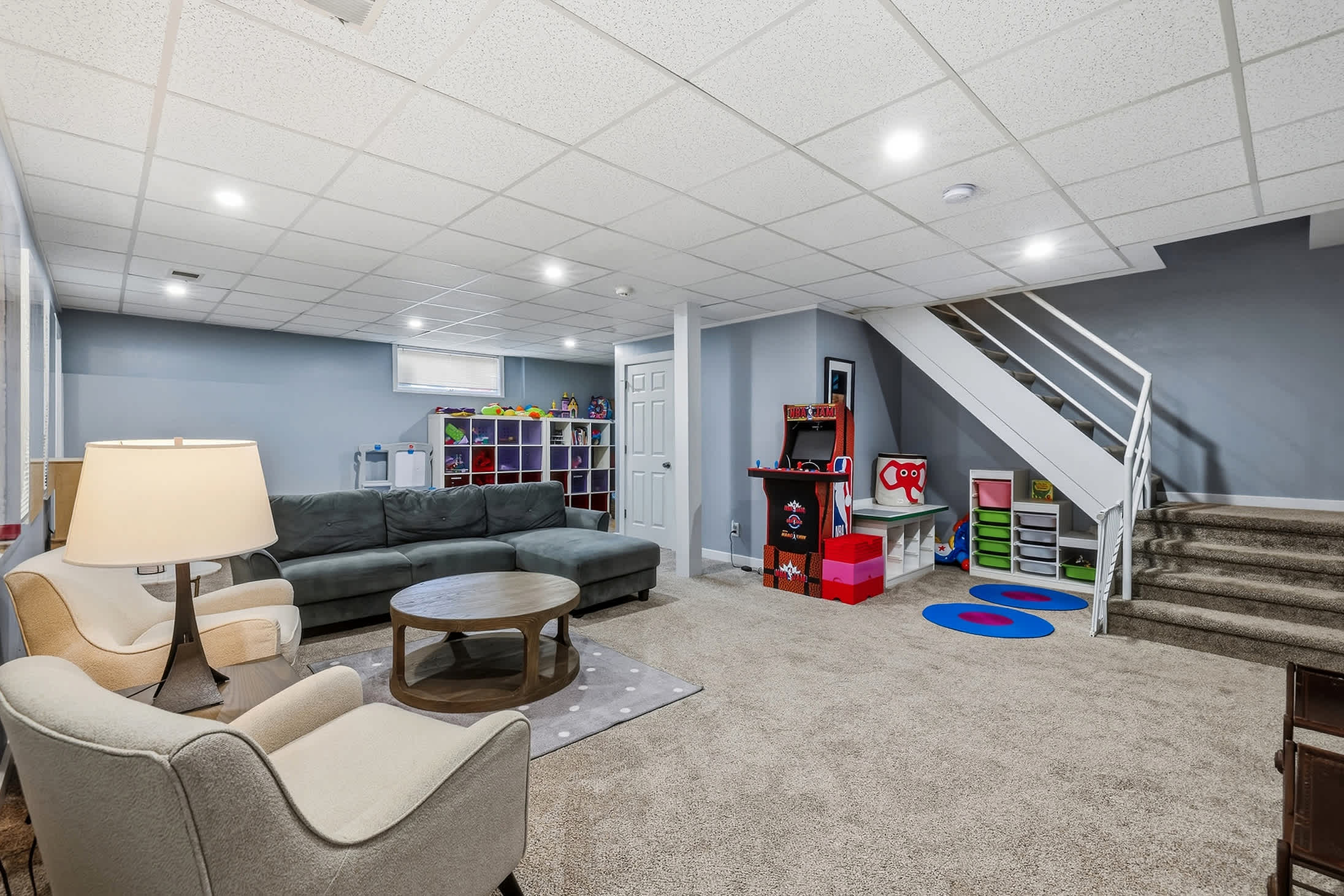 Basement recreation room with lounge seating, arcade game and kids play area
Lower level rec room with sofa seating, arcade game and space for kids.
