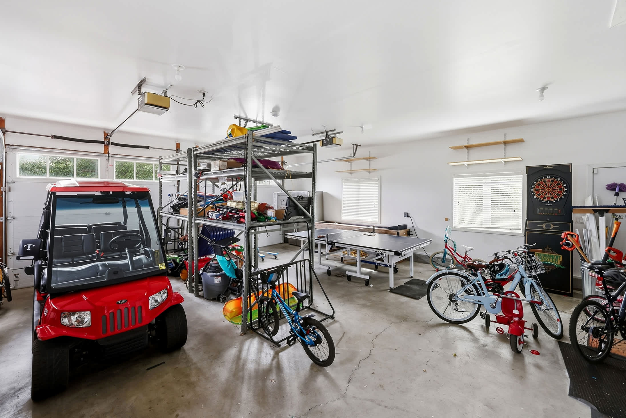 Garage game space with ping pong, darts, bikes and kids ride-on toys.