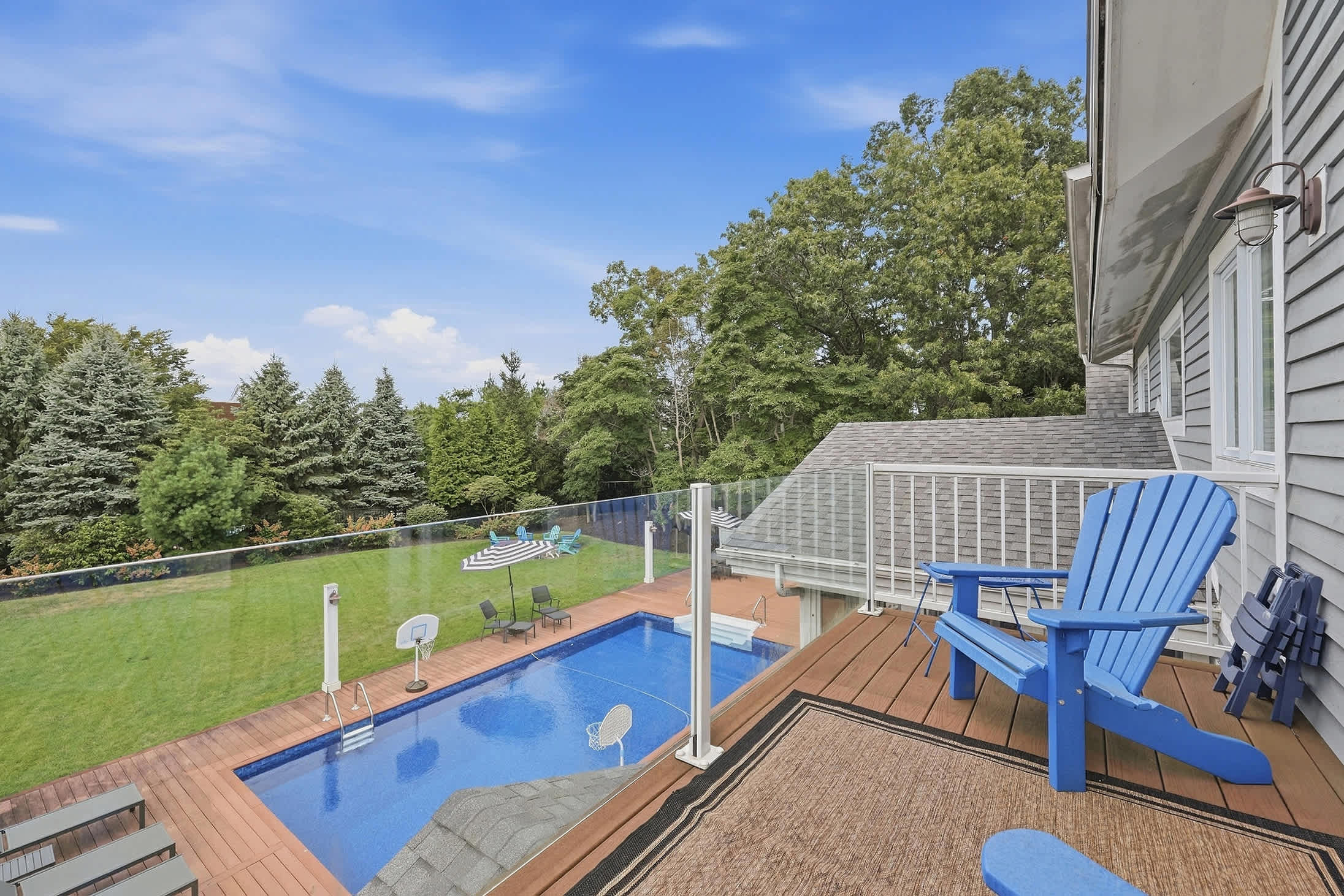 Upper deck with Adirondack seating overlooking the pool and backyard.