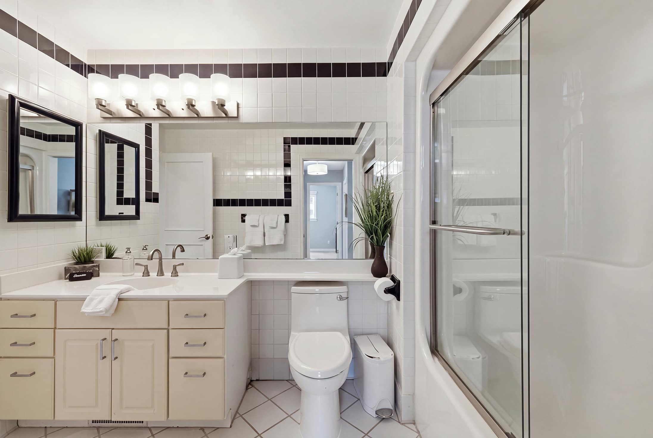 Full bathroom with tub and shower combo, vanity and ample counter space.