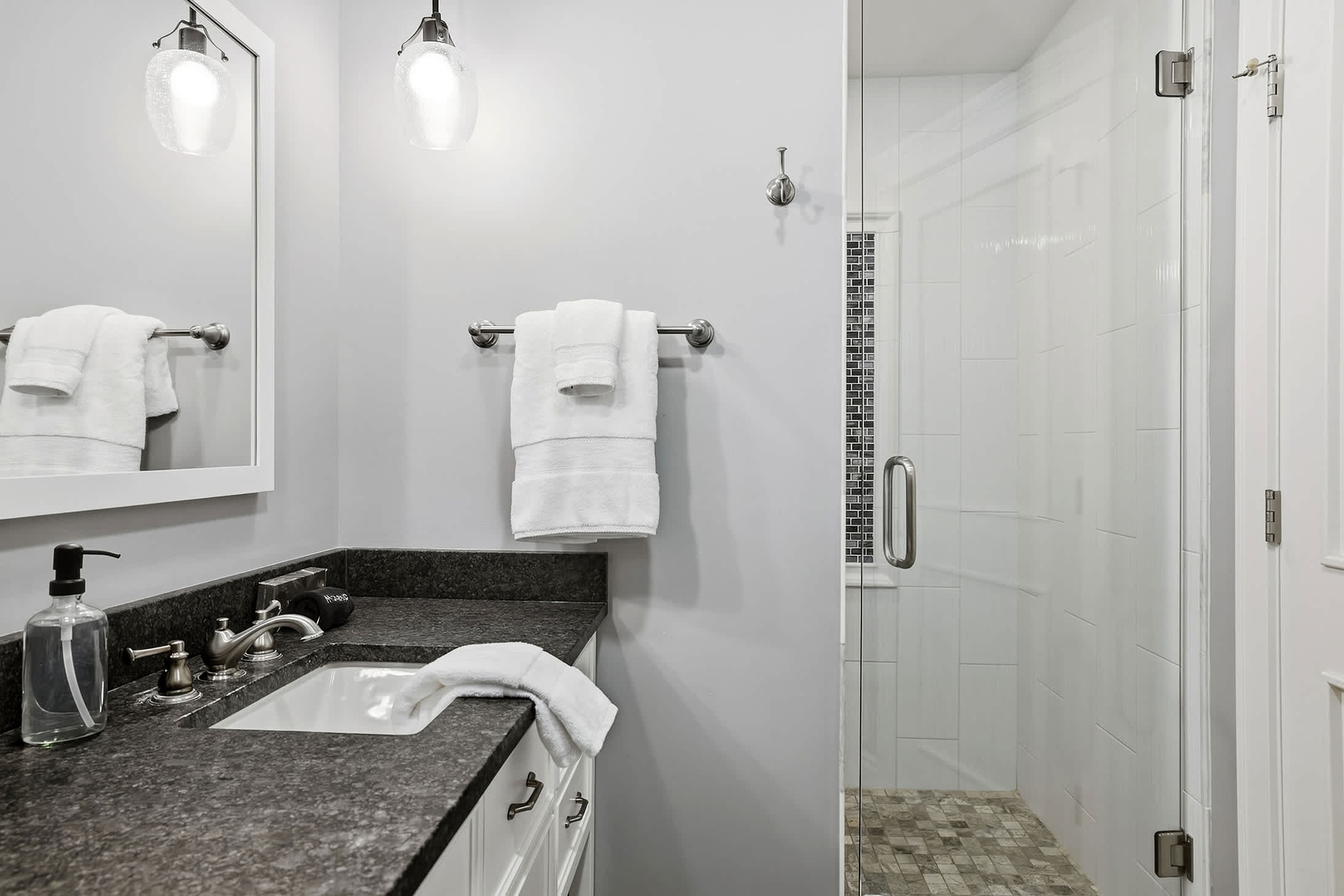 Full bathroom with walk in shower, vanity and fresh towel storage.