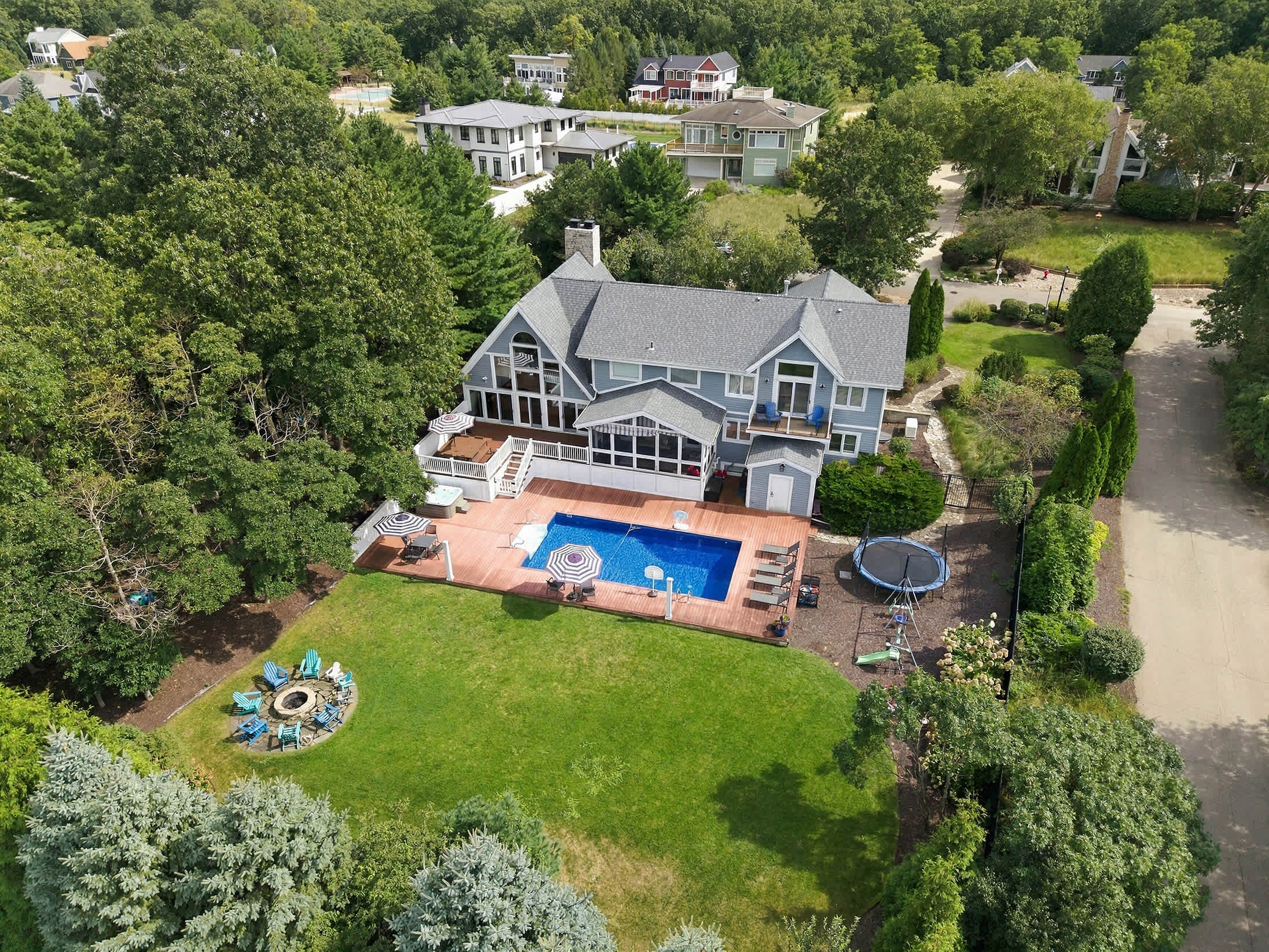 Main Destination with full backyard view with pool, deck, fire pit seating and family play space