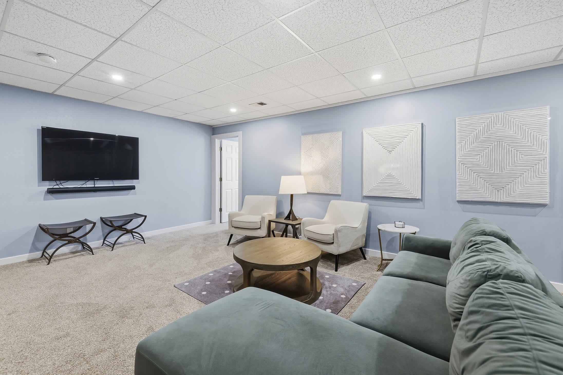 Basement lounge with large TV, sectional seating and room for movie nights