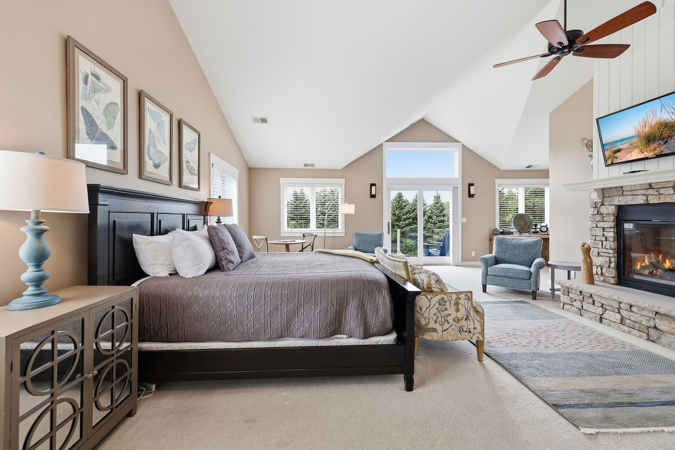 Large primary bedroom with fireplace, TV and room to unwind.