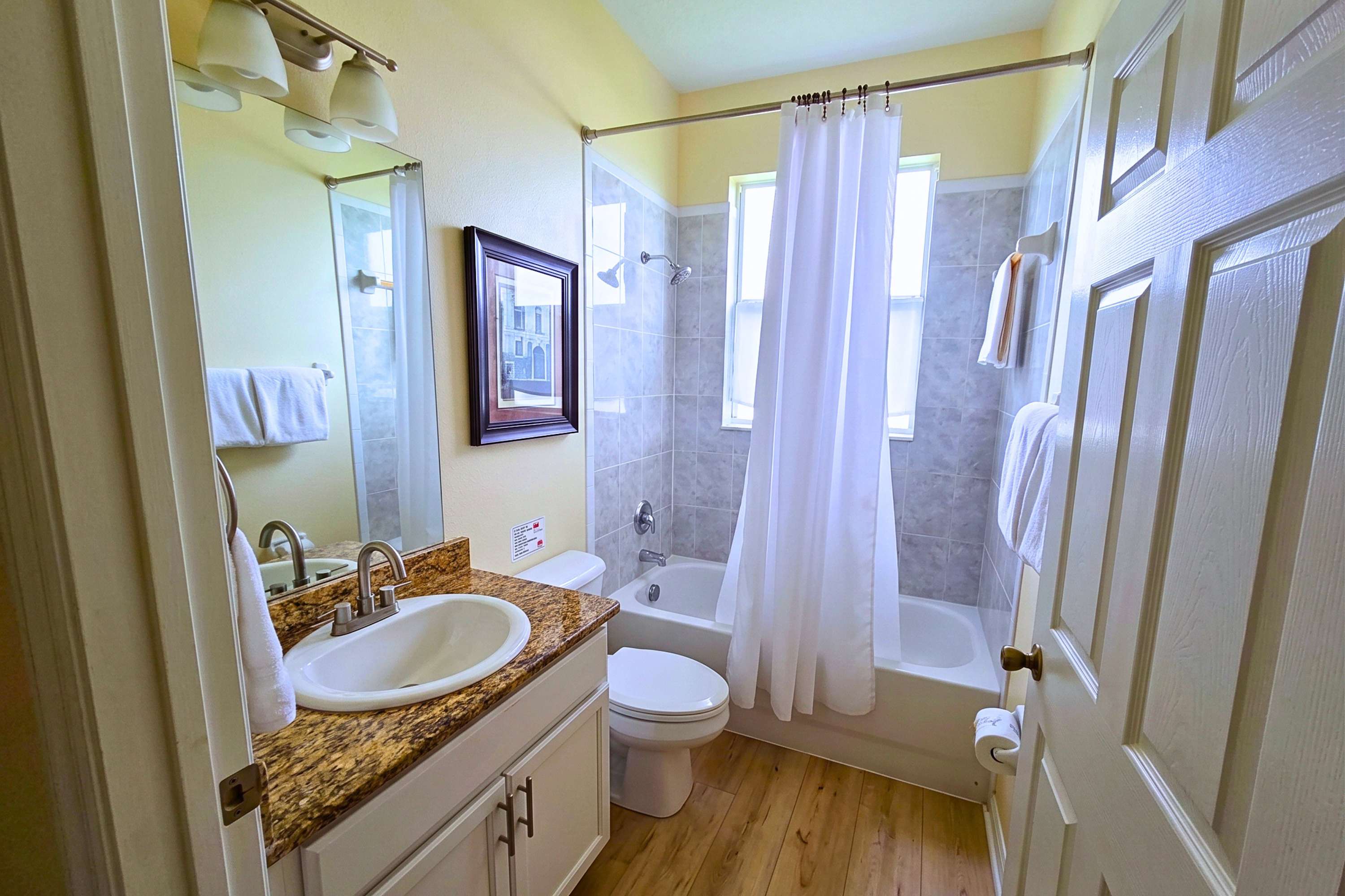 Clean, bright bathroom with modern fixtures and a full tub/shower, ready for your visit
