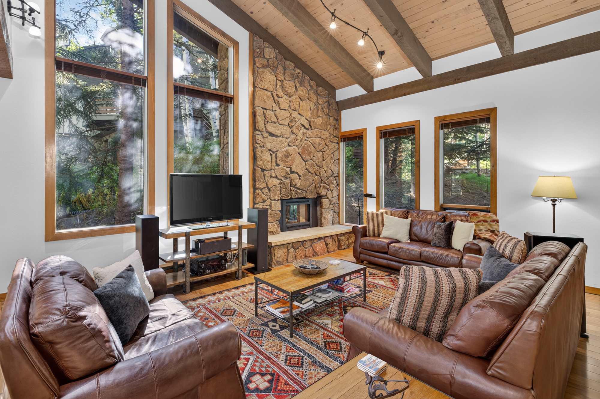 Spacious open living space with three couches, a Smart TV, and fireplace