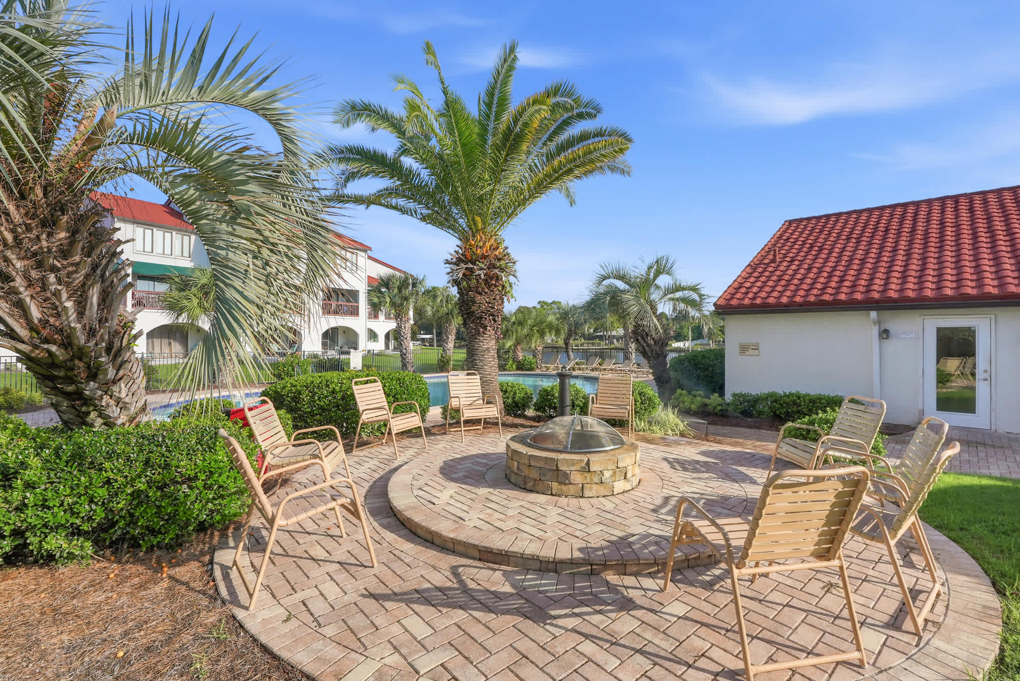 St Thomas SQ 1209C – Outdoor seating area with fire pit, palm trees, and views of a swimming pool.