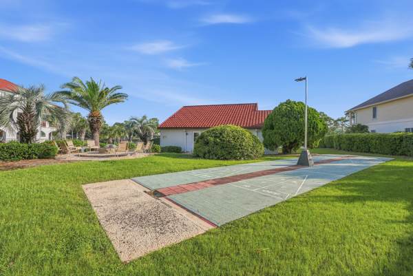 St Thomas SQ 1302B – Outdoor area with green lawn, palm trees, and a covered patio in St. Thomas.