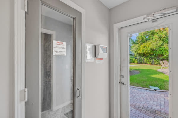 St Thomas SQ 1302B – Entrance area with doors leading to a yard, featuring a view of green grass and patio furniture.