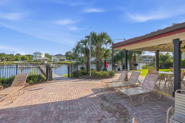 St Thomas SQ 1302B – Poolside area with lounge chairs overlooking a water view and nearby homes.