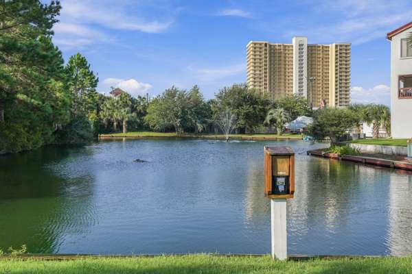 St Thomas SQ 1302B – Pond view with fountain, surrounding trees, and a tall building in the background.