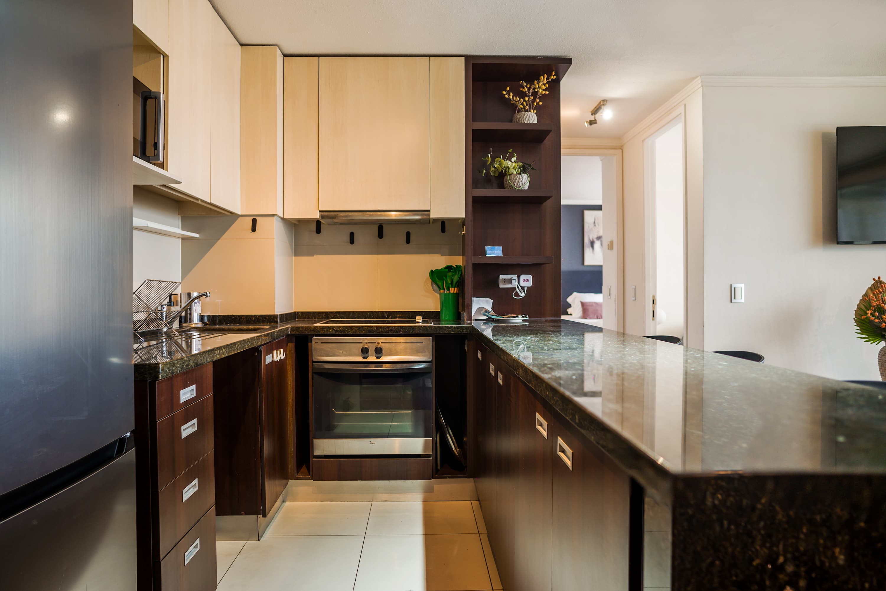 Private kitchen with granite countertops, full-size appliances, and a breakfast peninsula with bar seating.