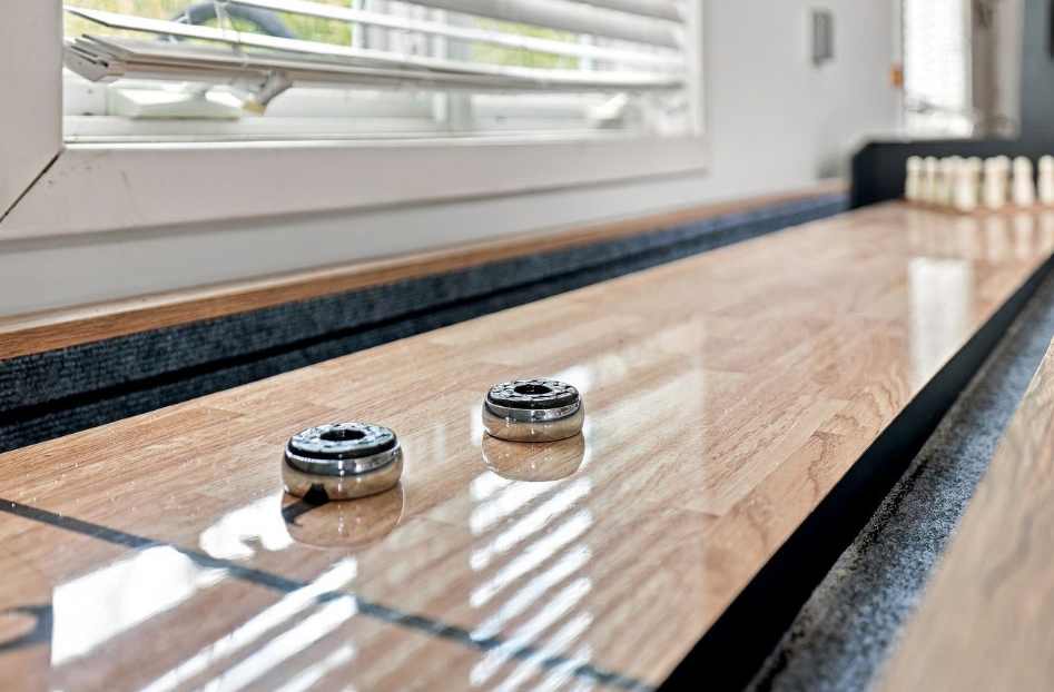 Shuffleboard in the garage with bowling pins for an easy game swap.