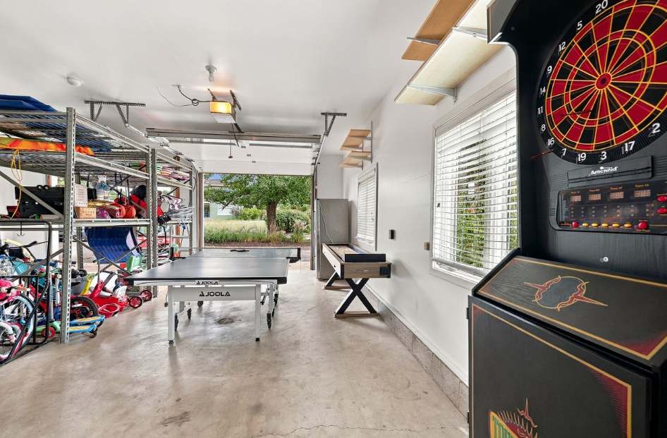 Garage game room with ping pong, shuffleboard, and electronic darts