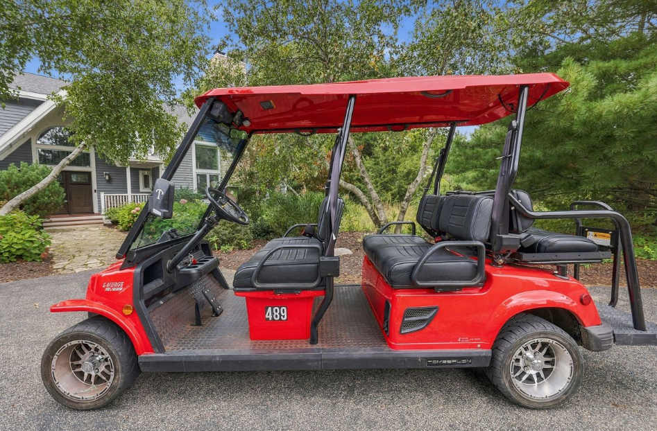 Grand Beach golf cart with three rows of seating and shade for beach runs.