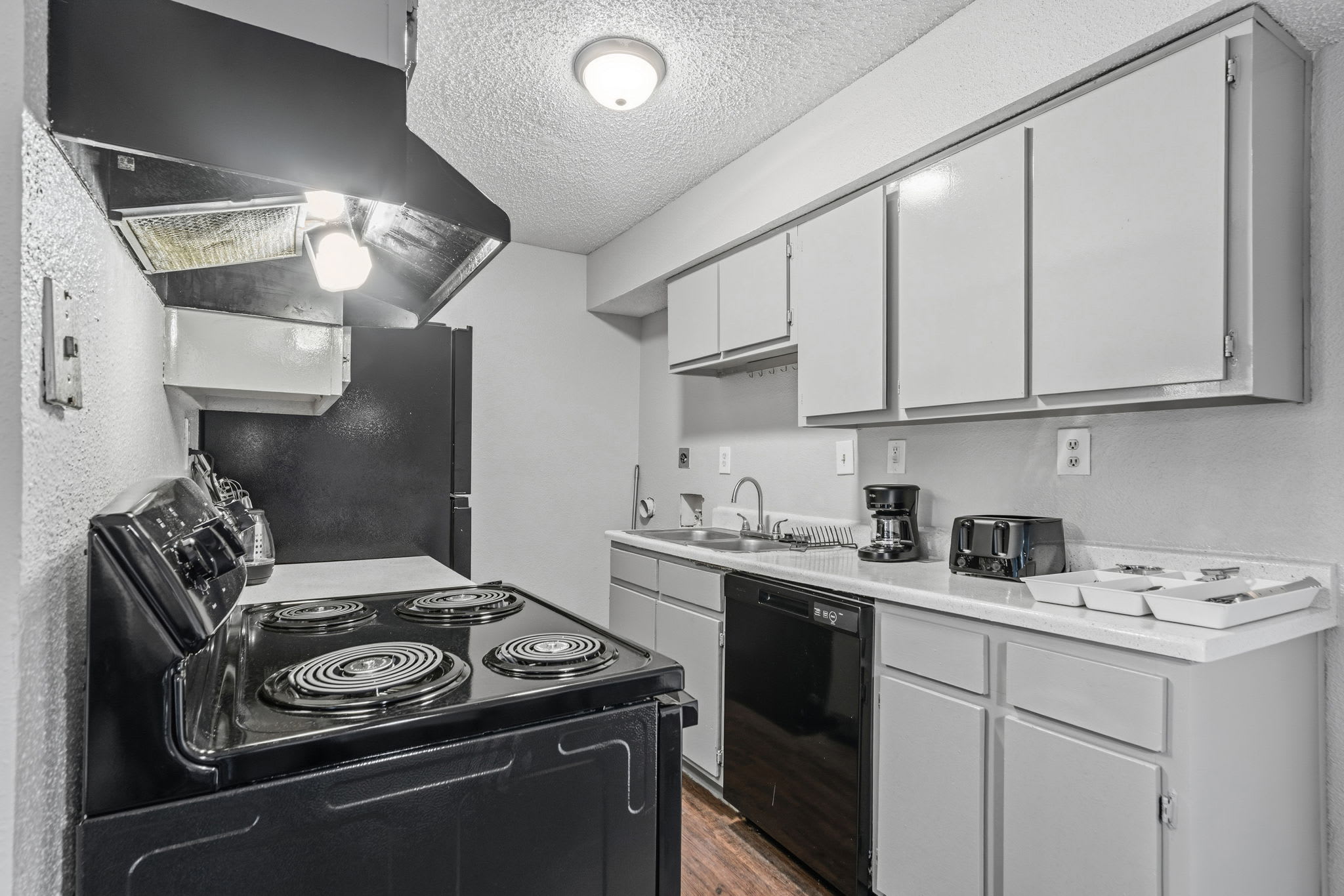 Compact private kitchen with a full electric range, dishwasher, coffee maker, and generous cabinet storage for convenient group meals.