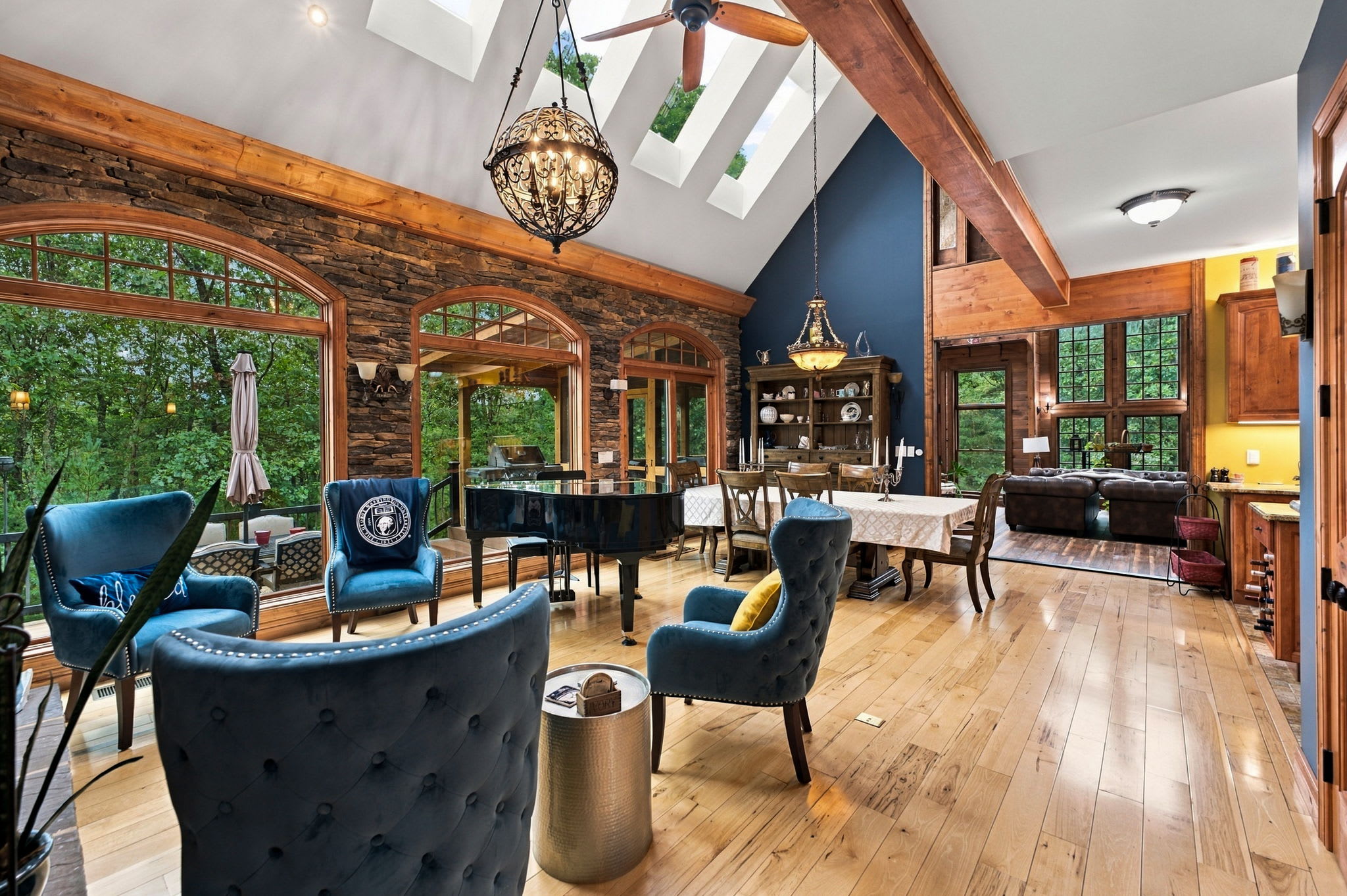 Soaring ceilings, skylights, warm wood details, and oversized picture windows create an impressive setting surrounded by woods and mountain scenery.