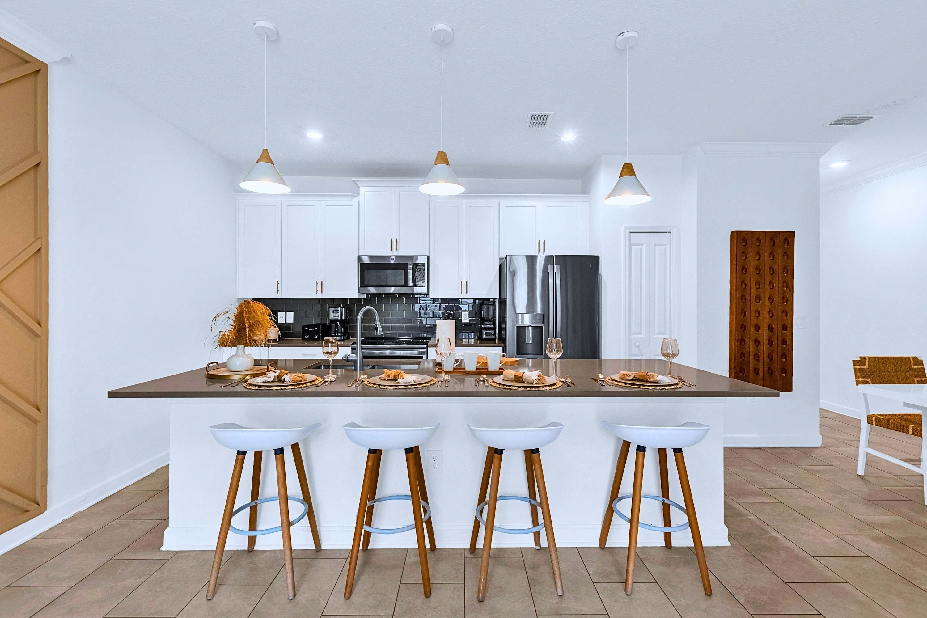 Chef's kitchen ready for meals, featuring an inviting island with counter seating.
