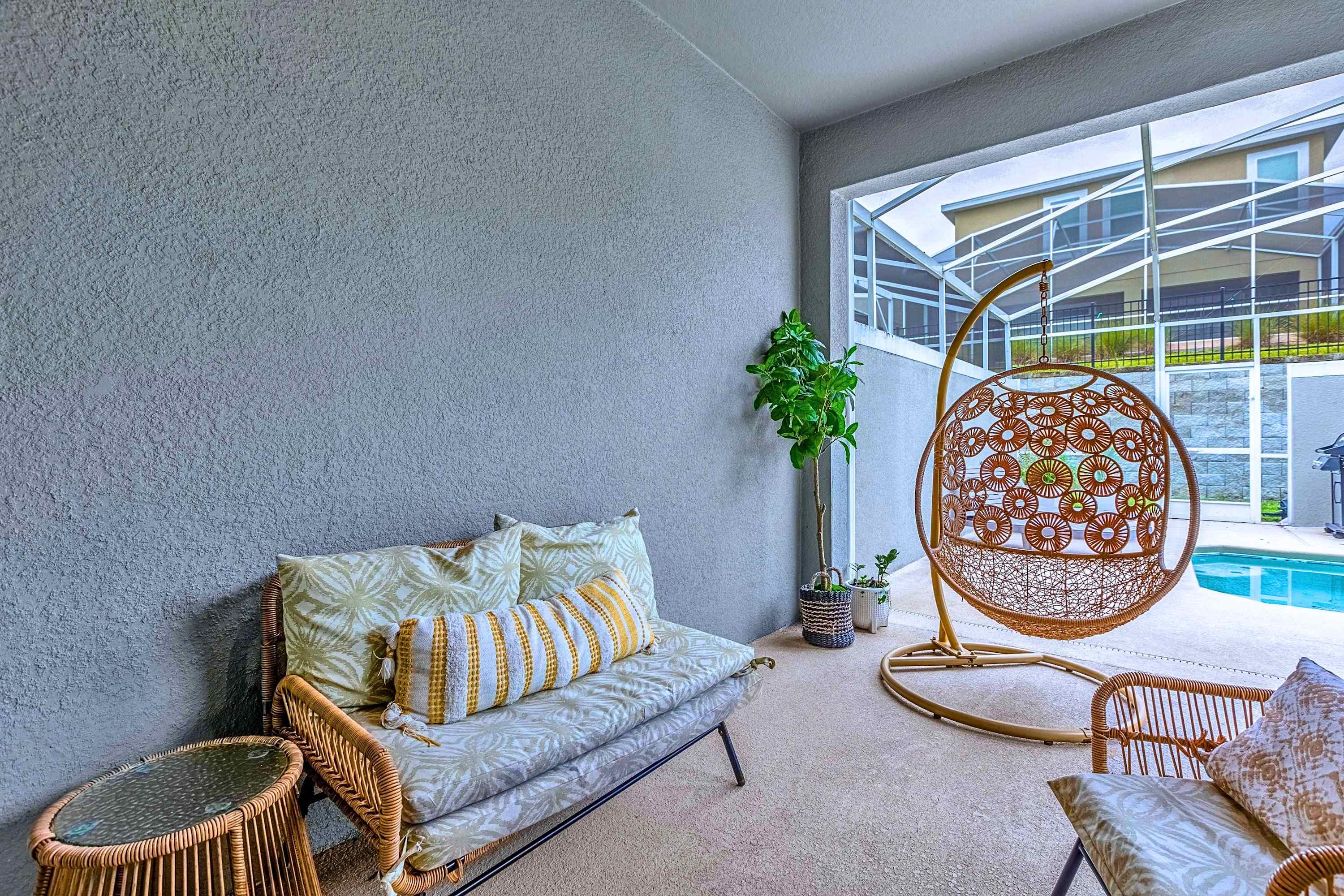 Unwind in style on the patio with a cozy hanging chair and shaded seating.