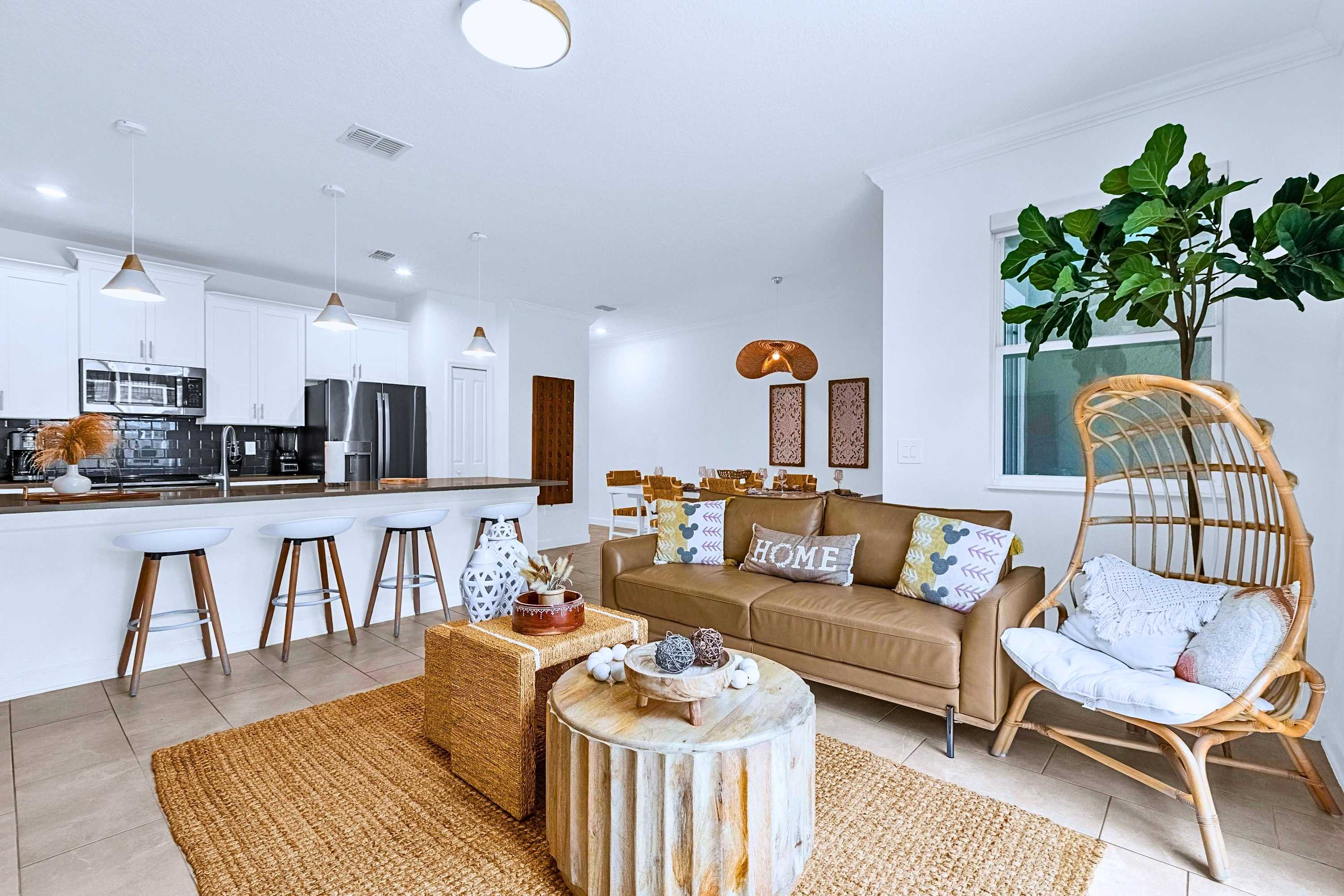 Main living room featuring a couch and accent chair, open to the kitchen center island.