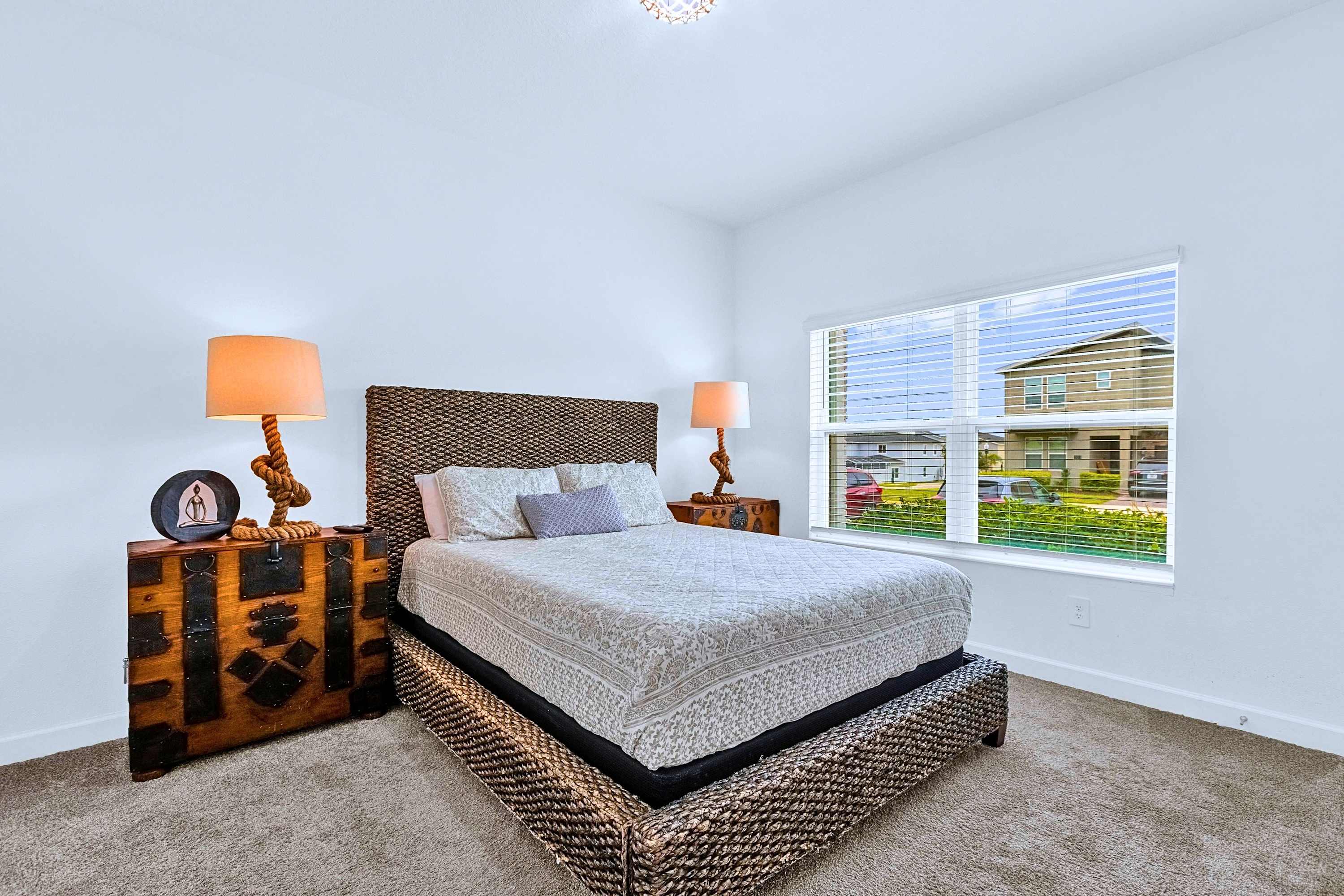 Sleep in luxury on a plush King bed with cozy bedding and soft nightstand lighting.